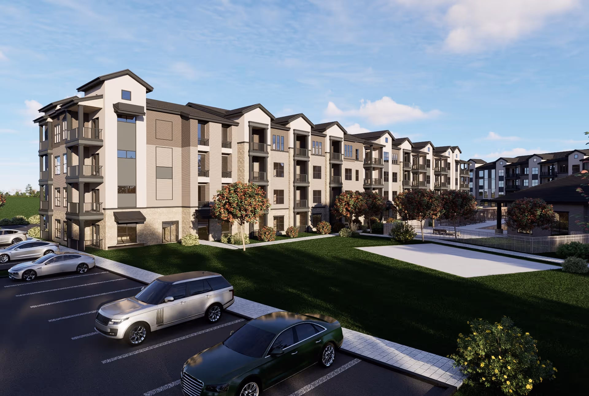 Modern four-story apartment complex with balconies, surrounded by landscaped green lawn, trees, and parked cars under a blue sky.