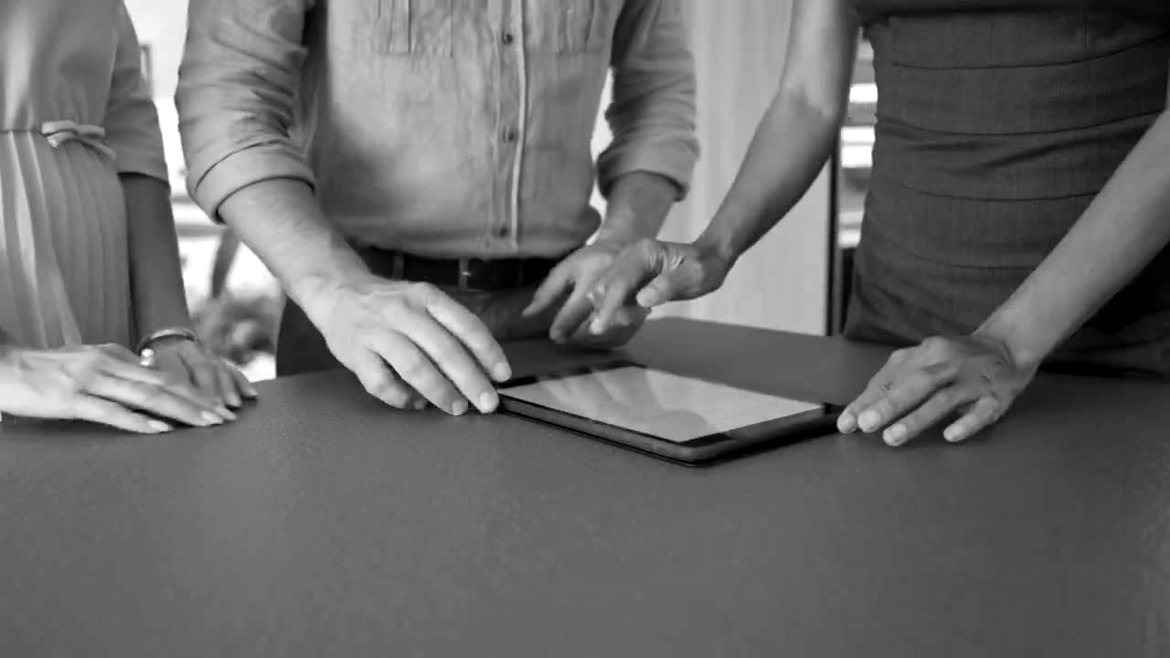 A rep and homeowners going over a quote on a tablet at the kitchen counter
