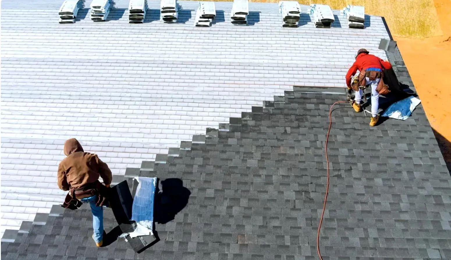 A roofing crew laying new shingles, the kind of job Connell Roofing sells