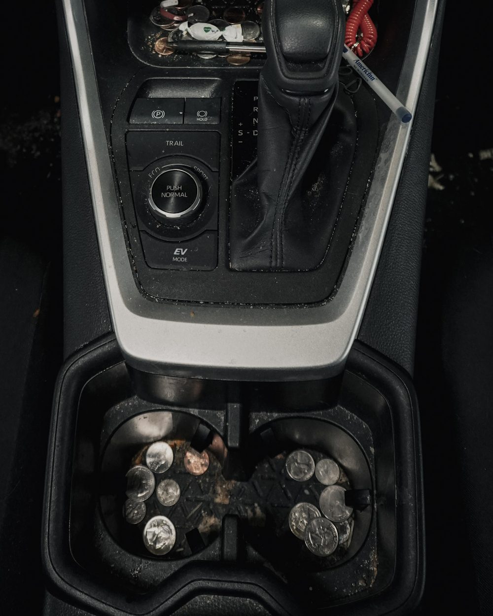 Toyota RAV4 center console and cup holders filled with coins and debris before professional interior detailing in Shakopee MN
