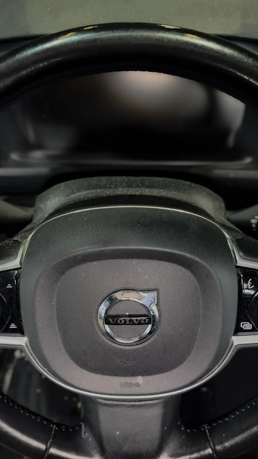 Dusty Volvo leather steering wheel with built-up grime on the hub and controls before professional interior detailing by High Shine Detailing in Shakopee MN