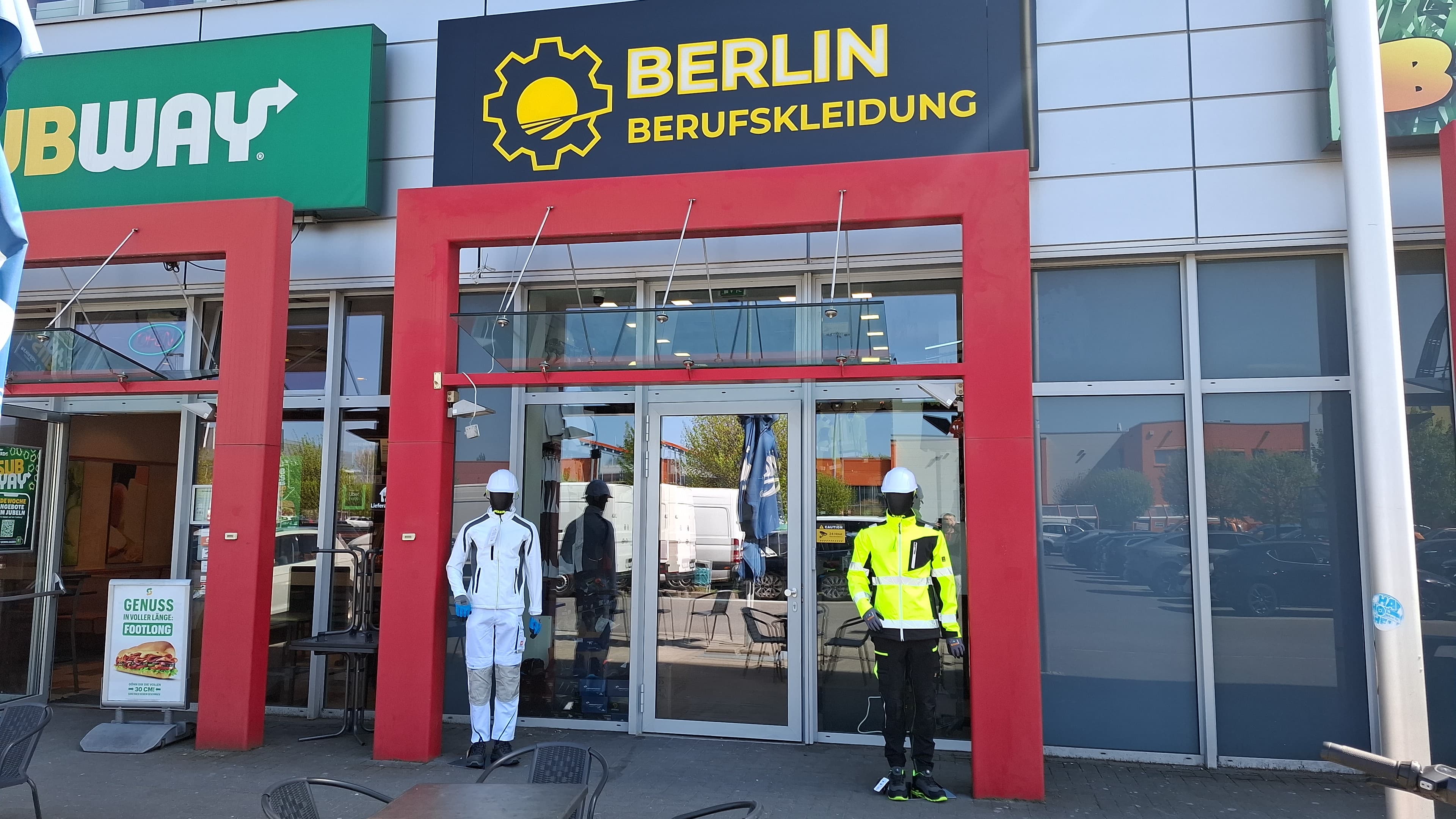 Eingang von Berlin Berufskleidung mit zwei Schaufensterpuppen in Arbeitskleidung vor der Tür.