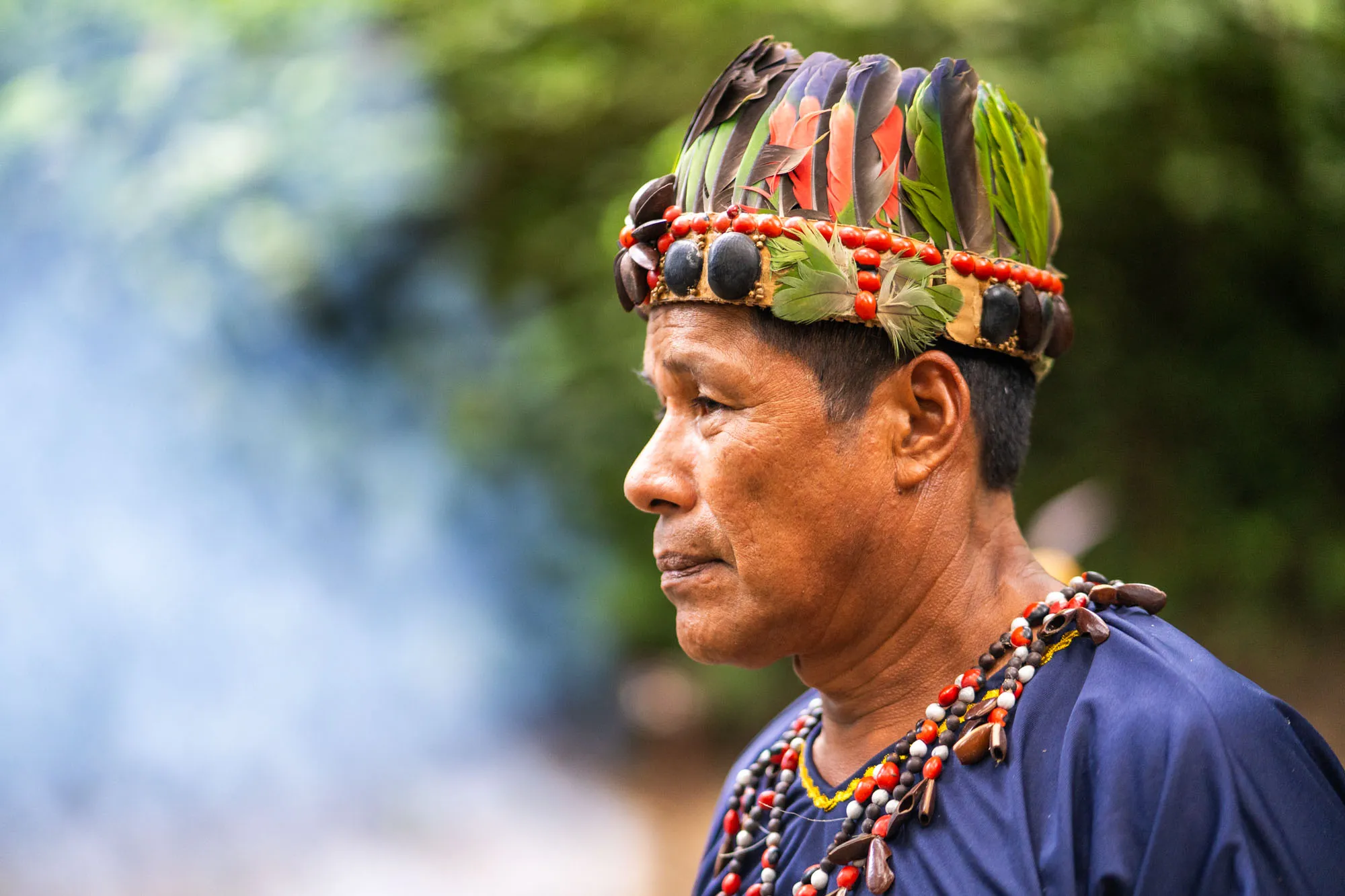 a local shaman wearing a headdress with feathers on his head