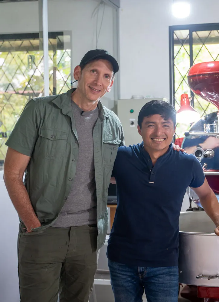 two men standing next to each other in a room