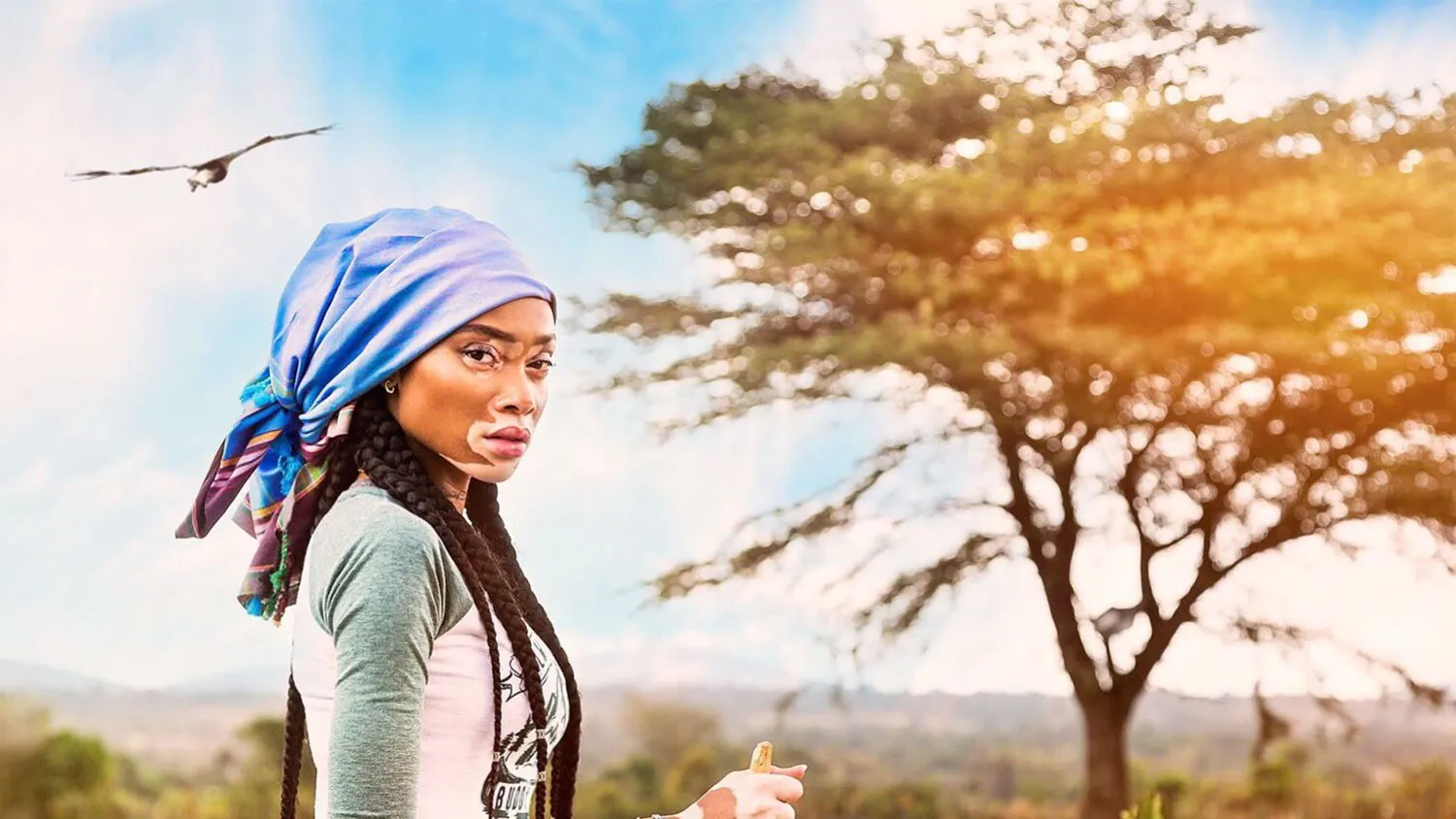 a woman with dreadlocks and a blue head scarf