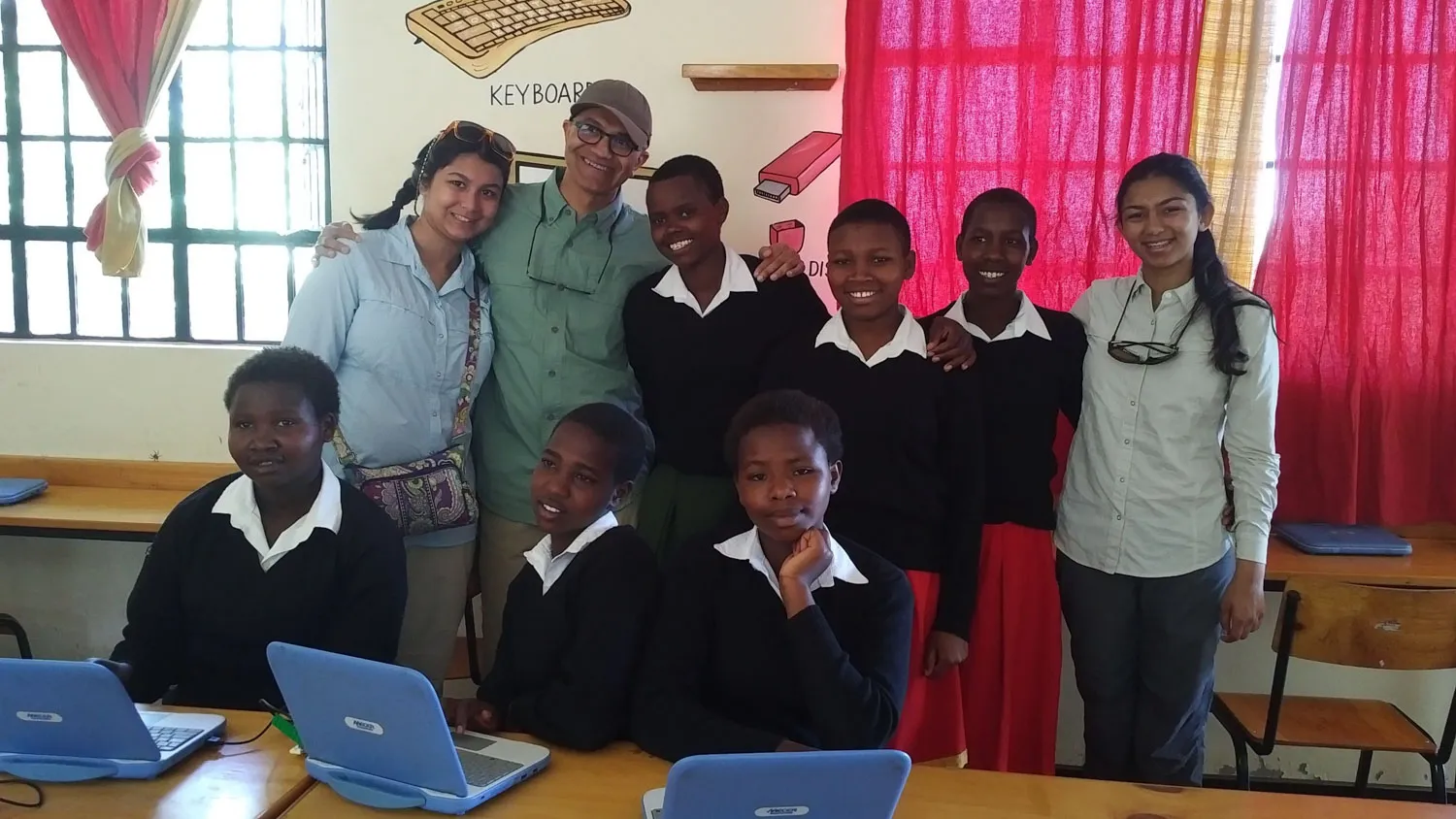 a group of students posing for a picture in front of their laptops