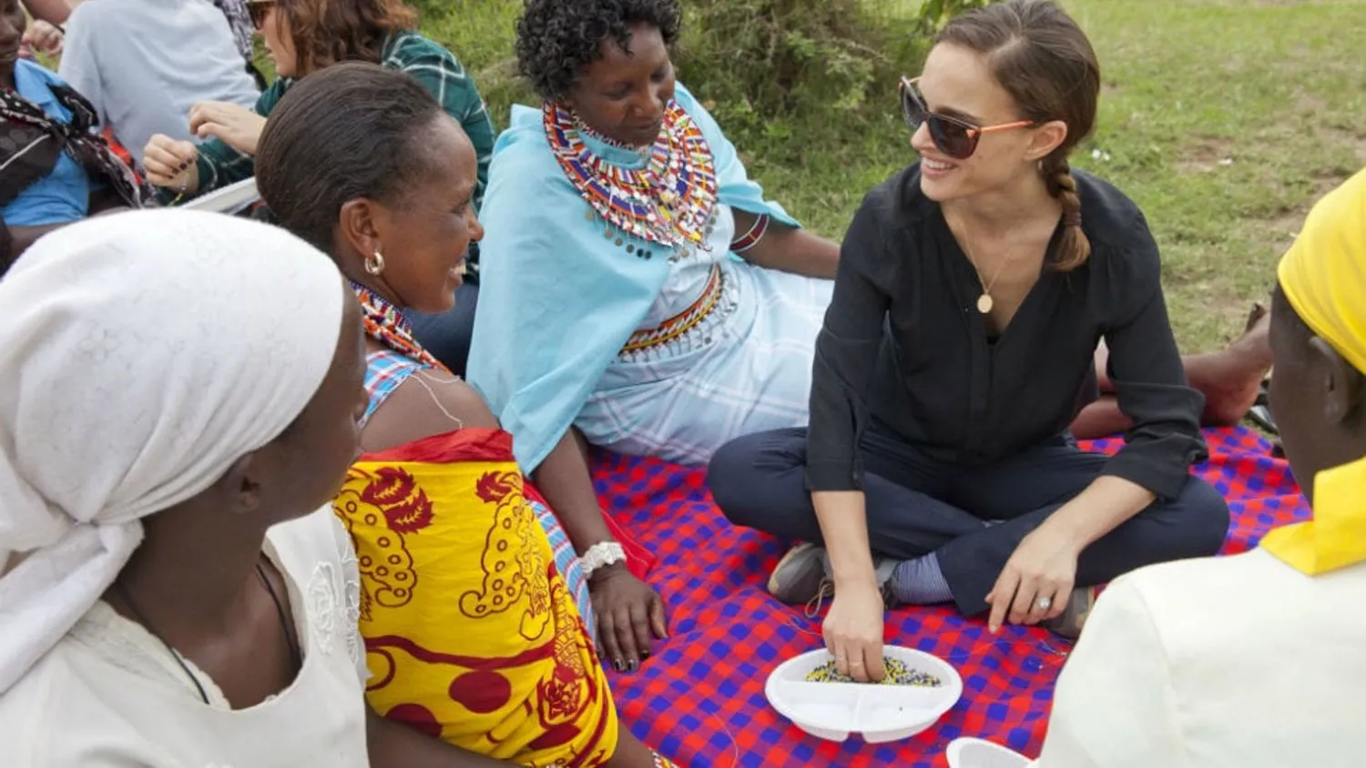 a group of women sitting around each other on a blanket