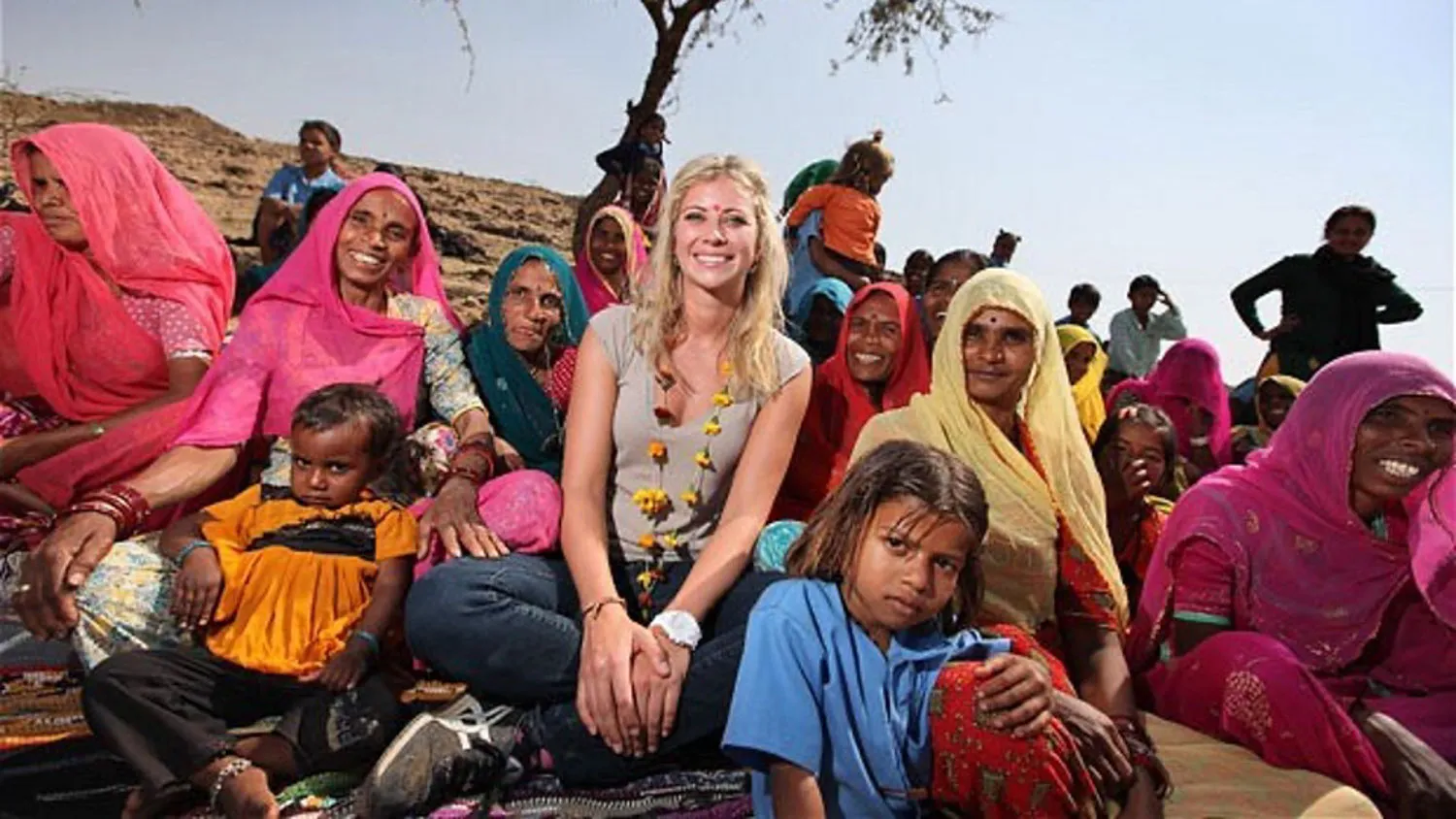 a group of women and children sitting on the ground