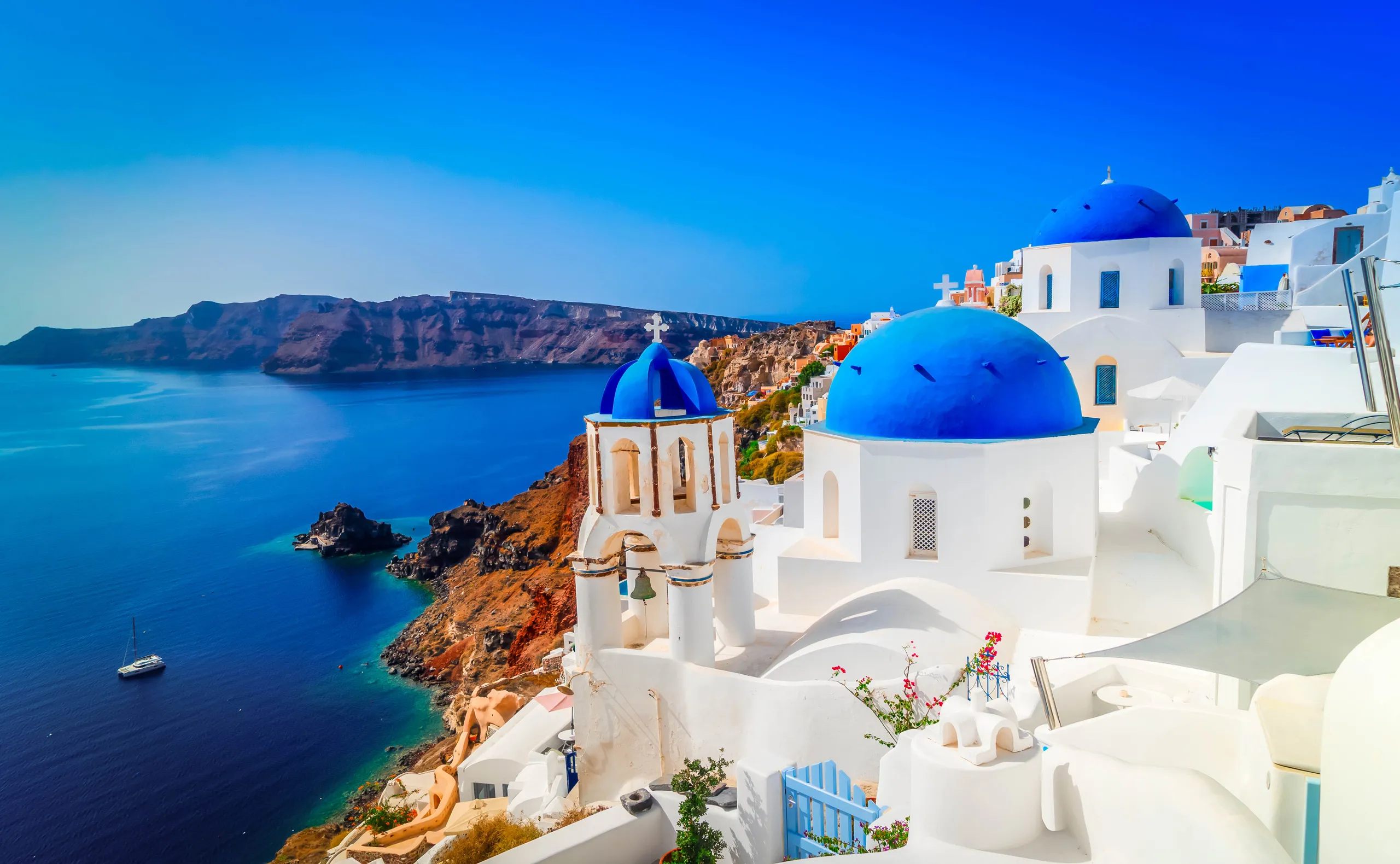 White churches with blue domes above the Santorini caldera in Oia, Greece