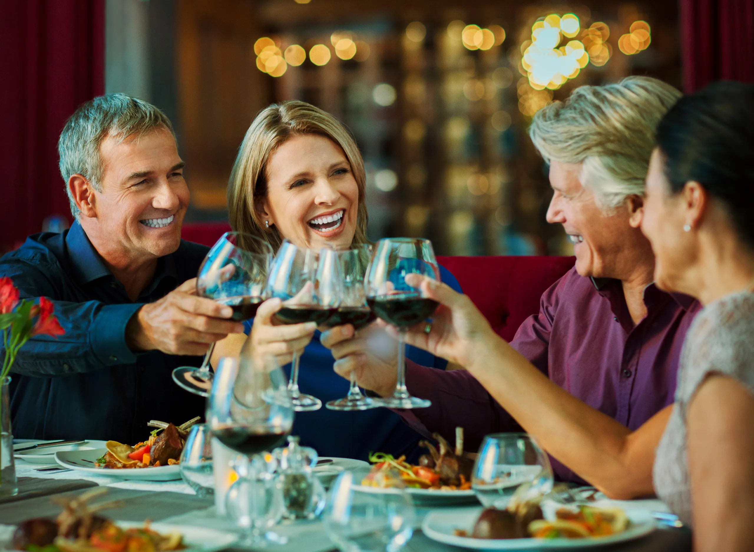 Four travelers raising a toast together over dinner
