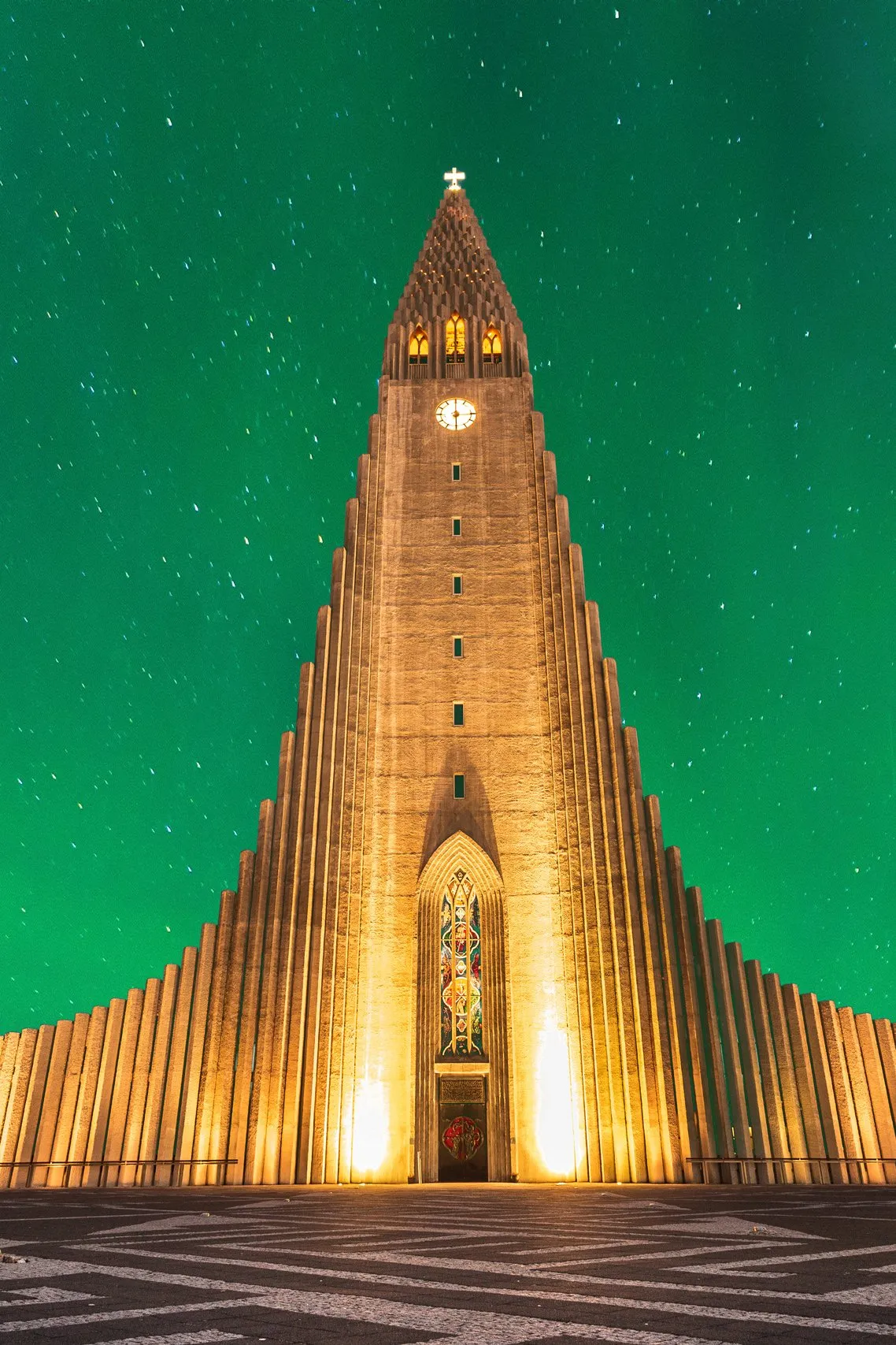 Hallgrimskirkja church in Reykjavik glowing beneath the green northern lights