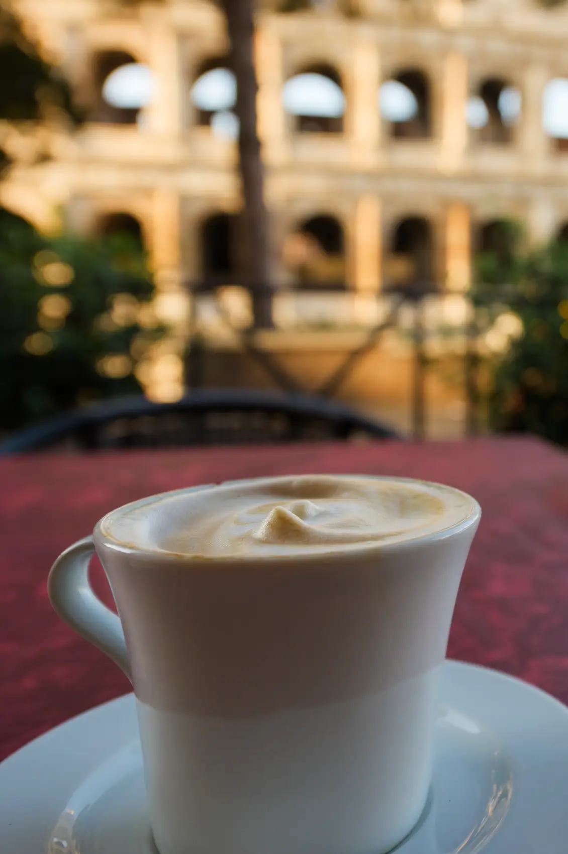 Cappuccino on a cafe table overlooking the Colosseum in Rome