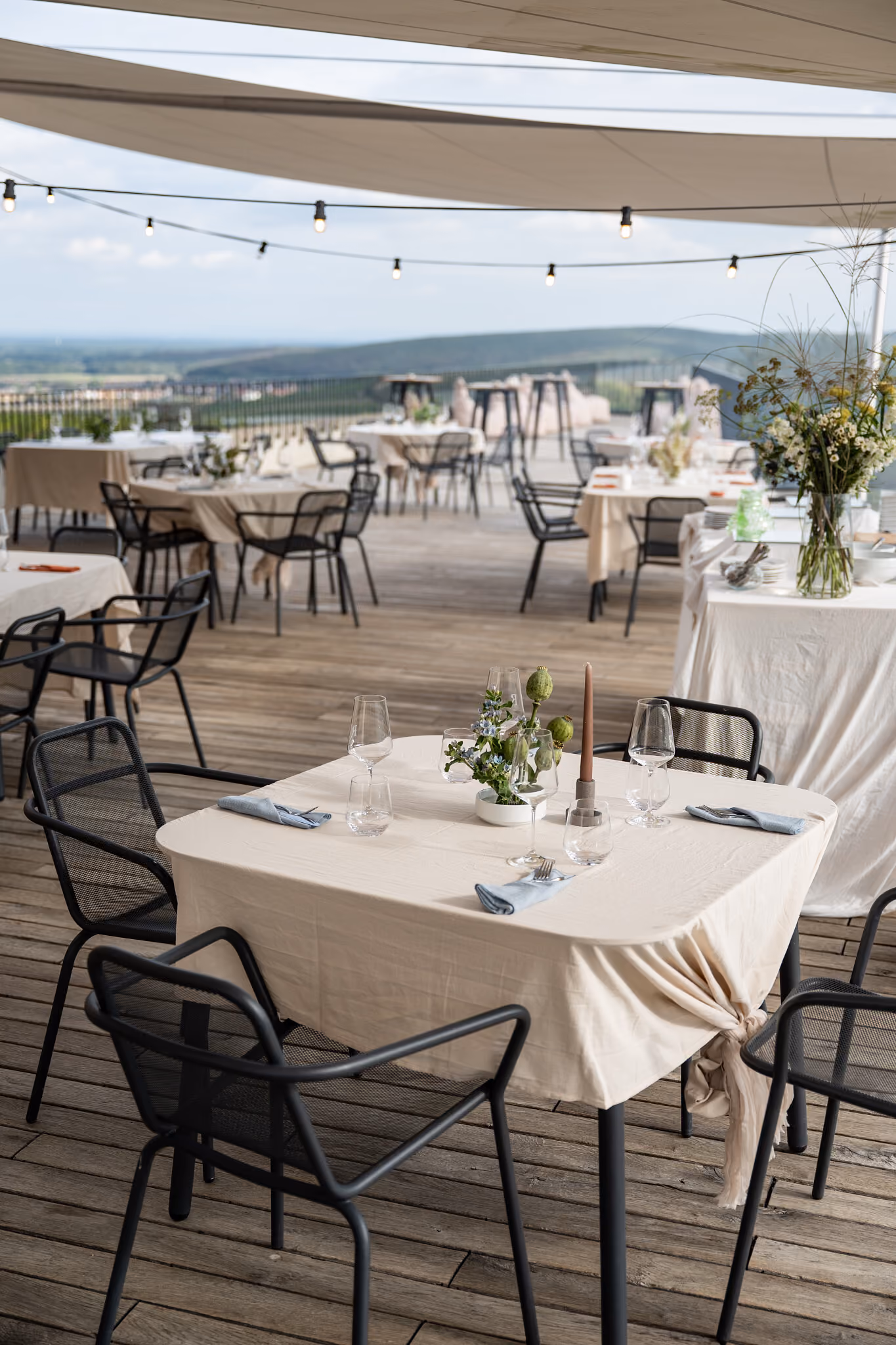 Muž v zástěře připravuje jídlo u venkovního grilu s nápisem Reisten Wine Bar na pozadí.