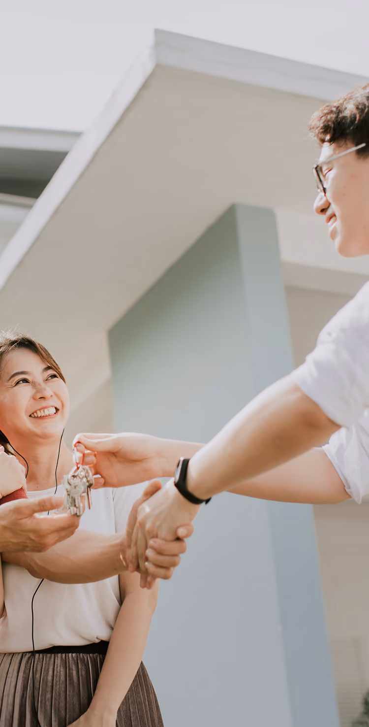Real Estate Agent handing keys to couple buying a home