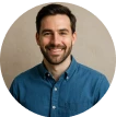 A man in a blue shirt is smiling.