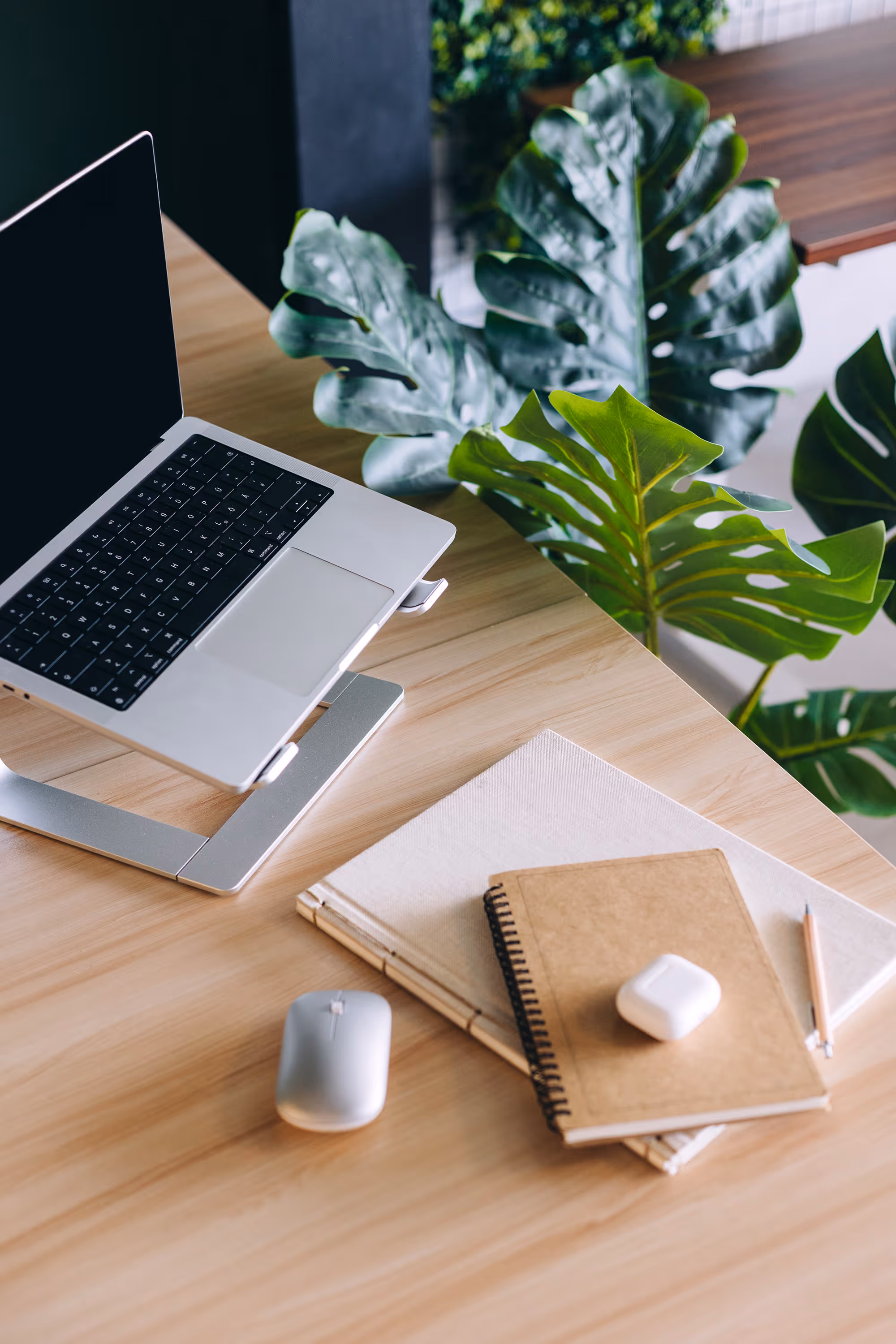 Laptop and notebooks on a bold green office desk