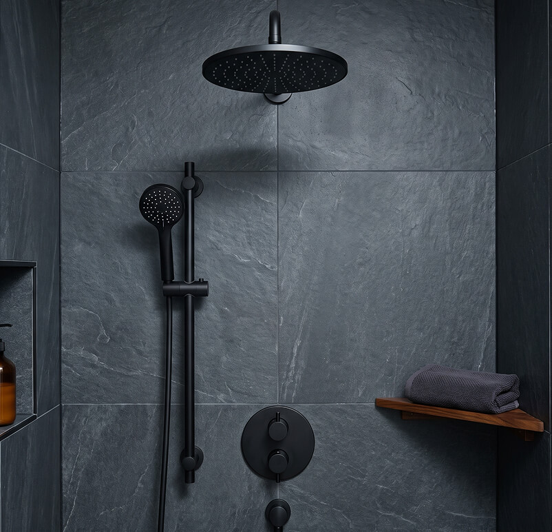 Modern bathroom with floating vanity, lit mirror, wall cabinet, toilet, and glass shower enclosure.