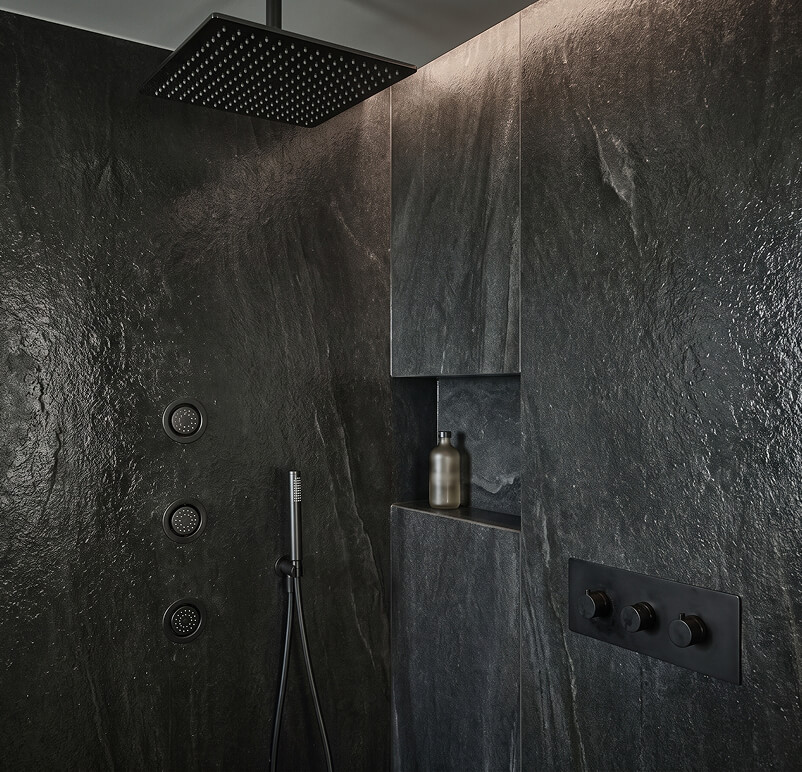 Modern bathroom with floating vanity, backlit mirror, wall-mounted toilet, and glass shower enclosure.