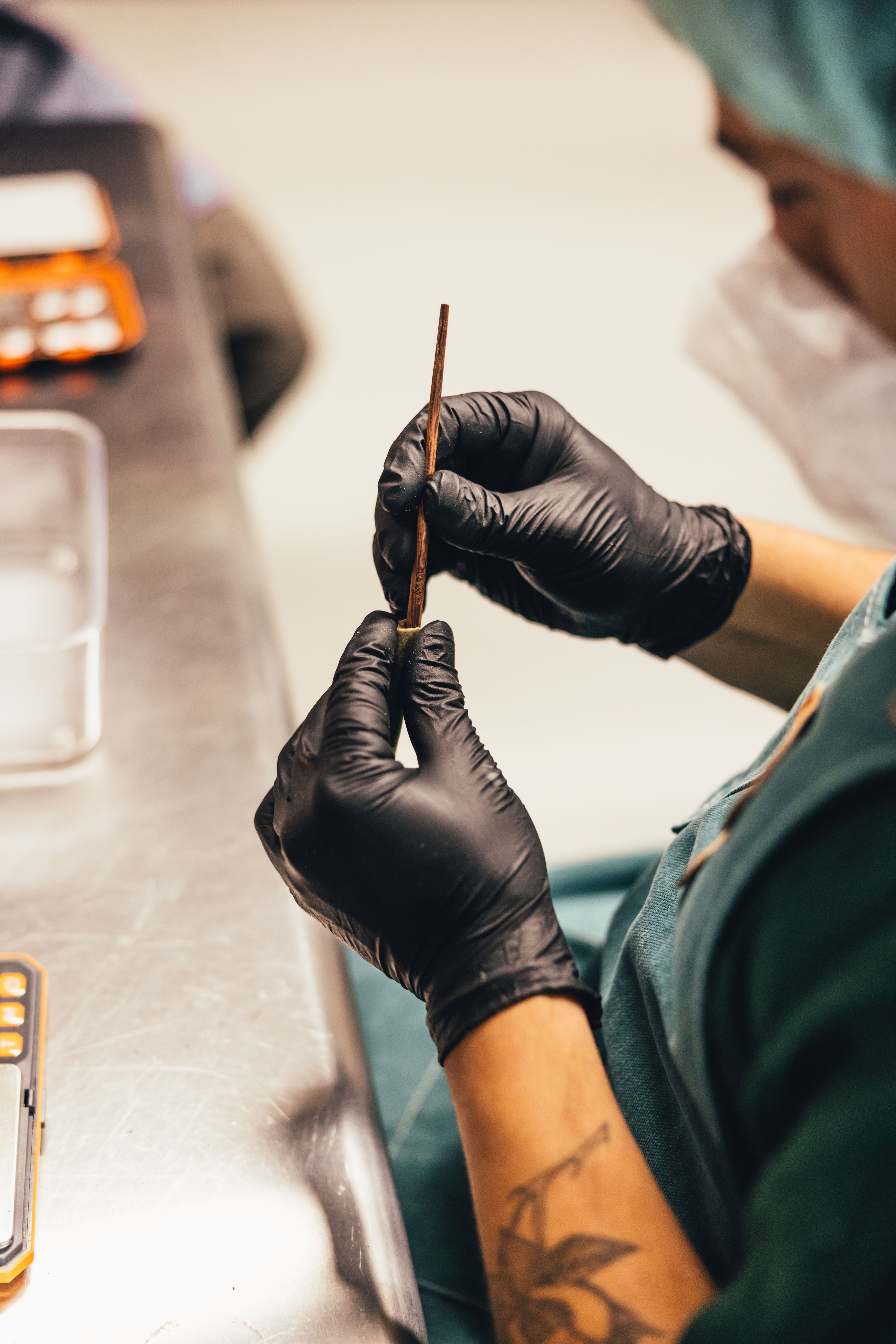 A Production Technician tampering down a cannabis pre-roll