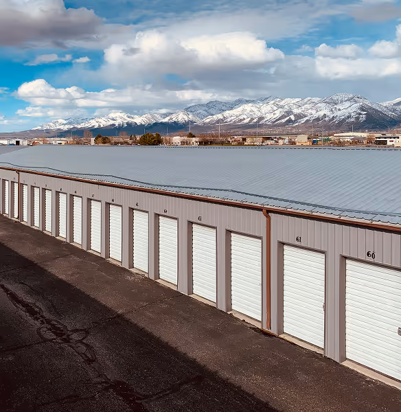 Row of self-storage units with snow-capped mountains behind them