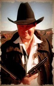 Man in cowboy hat and jacket holding two pistols against a desert background.