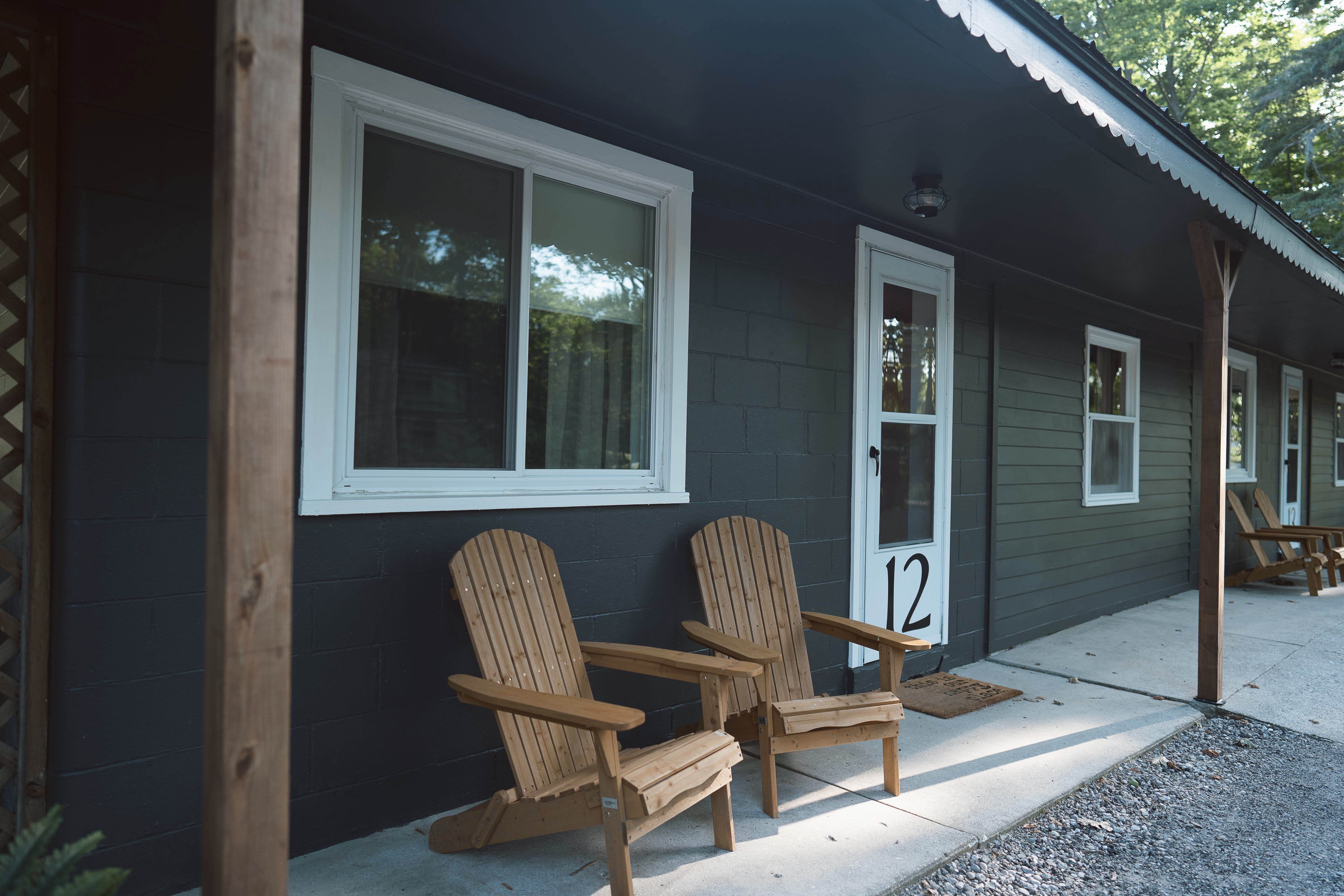 Lakeside Heritage Resort guest rooms with wooden Adirondack chairs outside Room 12 near Mackinaw City, Michigan.