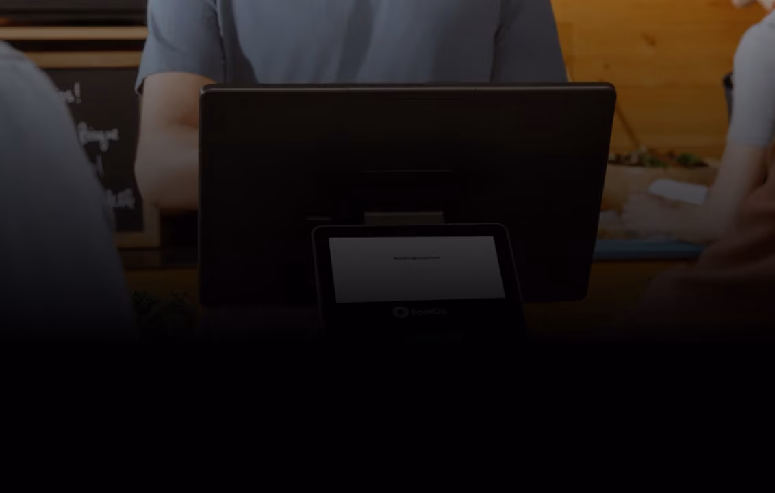 Point-of-sale system with payment screen at a counter and people behind it.