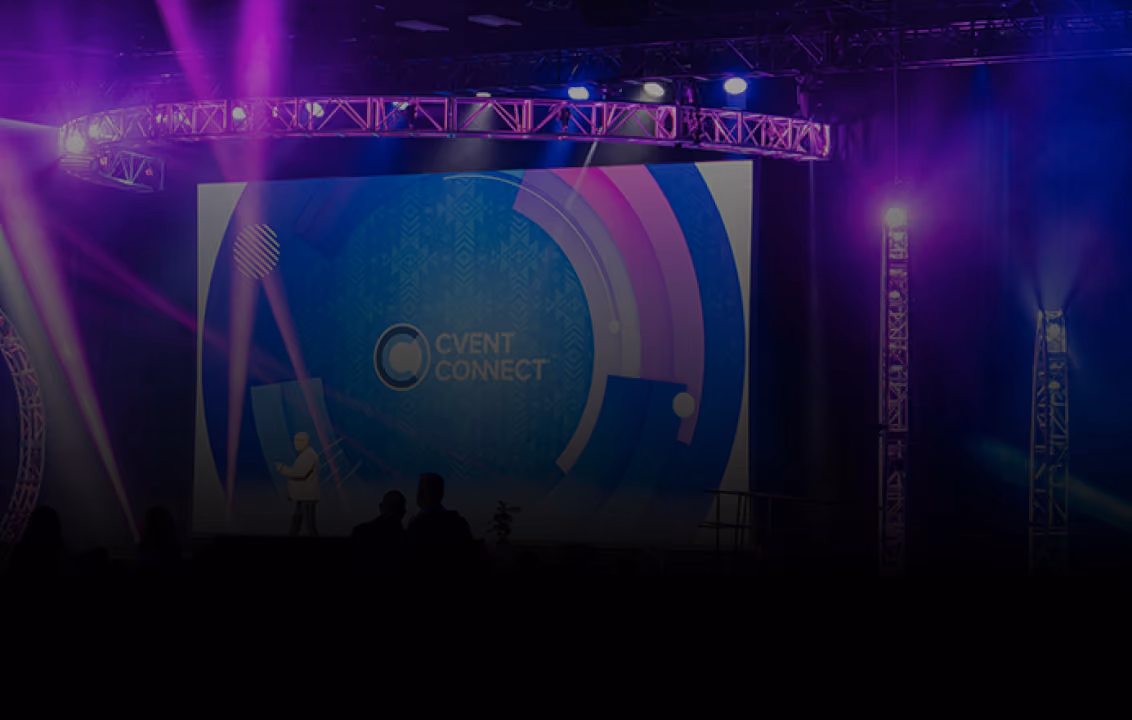 Speaker on stage with a large screen behind displaying Cvent Connect logo and purple lighting effects.