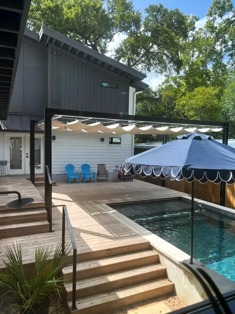 Pergola shade over the deck seating, with steps down to the pool