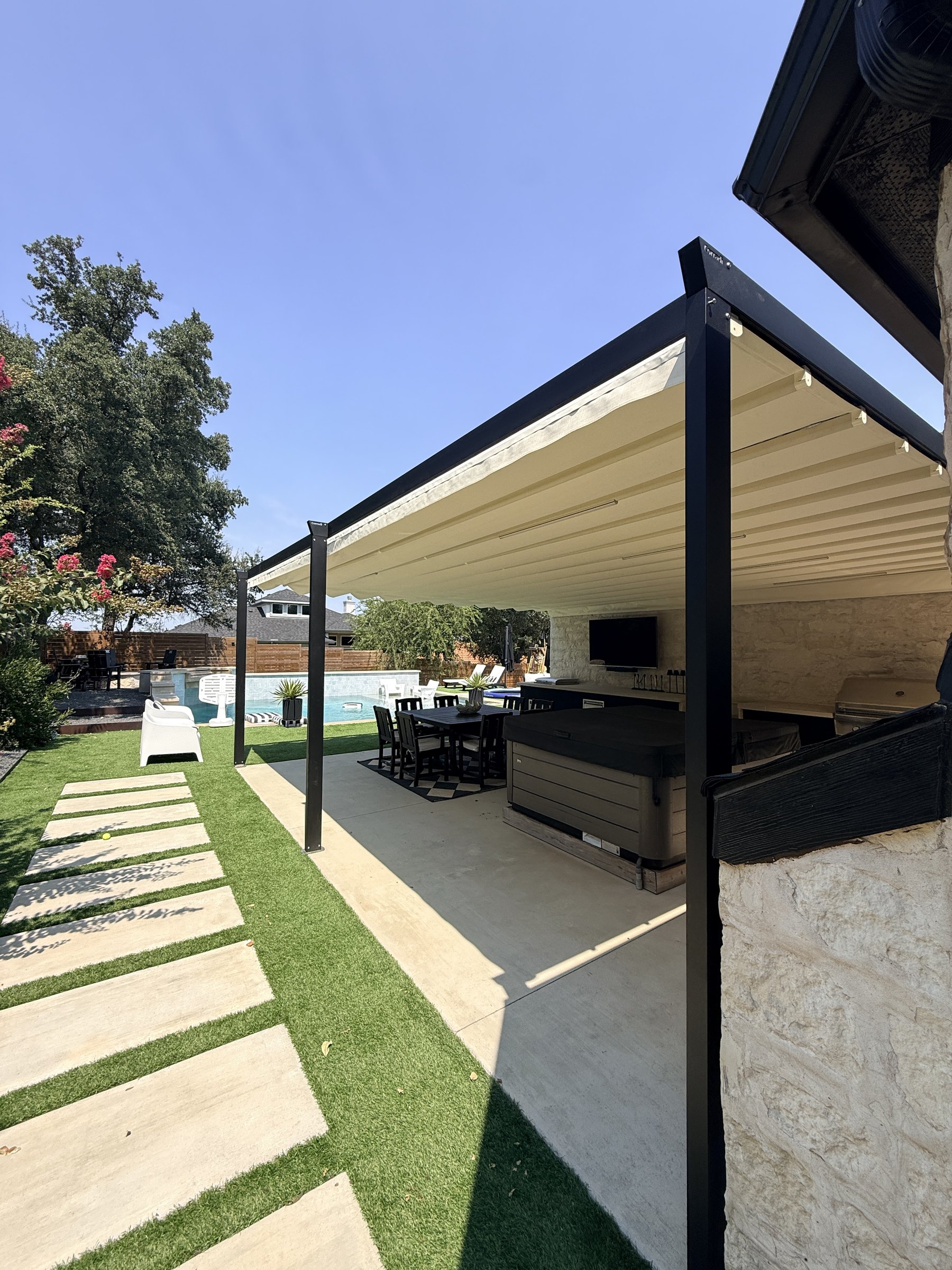 Carbon-frame Palladia pergola beside the turf and pool, canvas extended