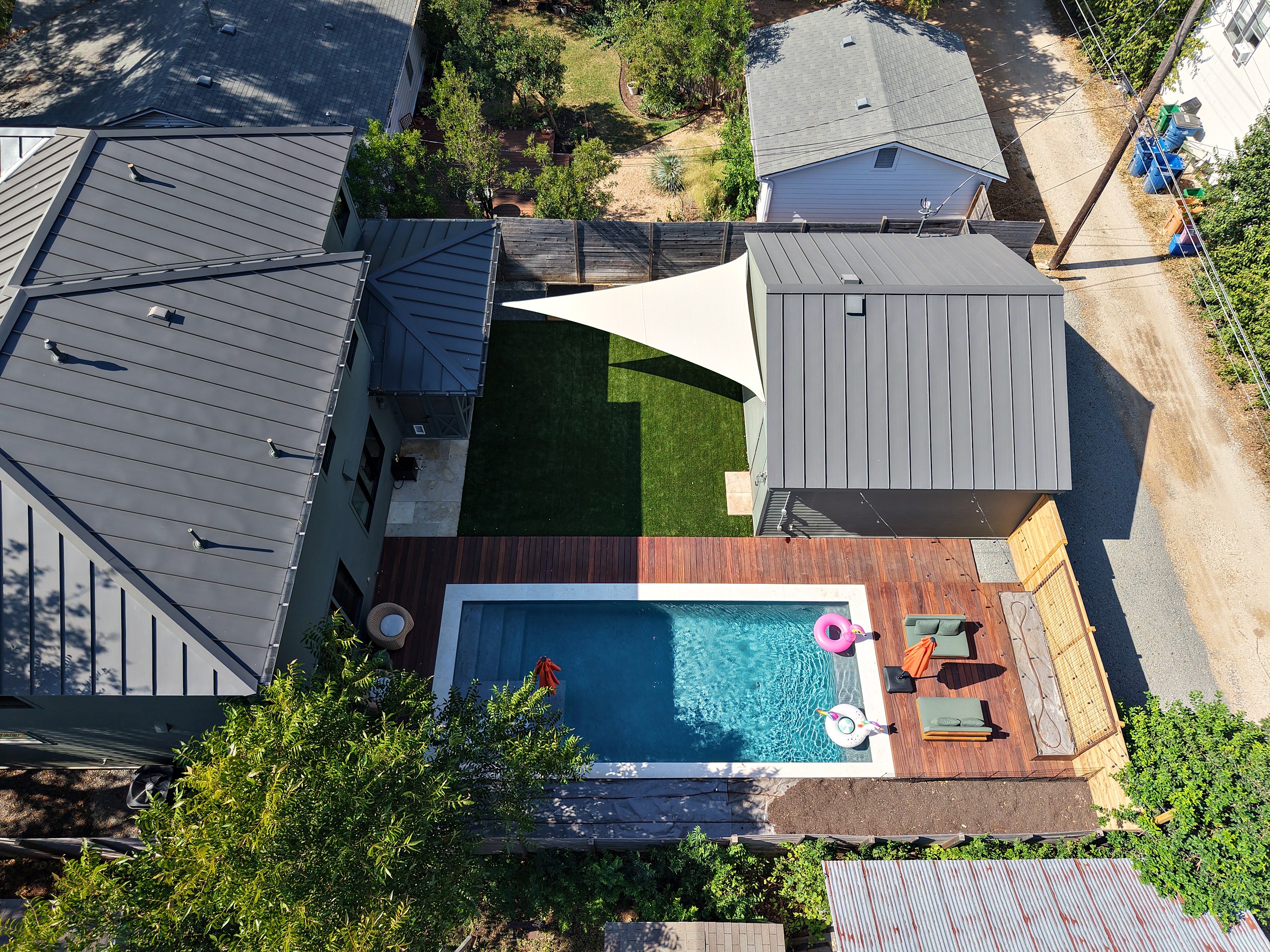 Drone view of the natural triangle sail over a turf yard beside the pool