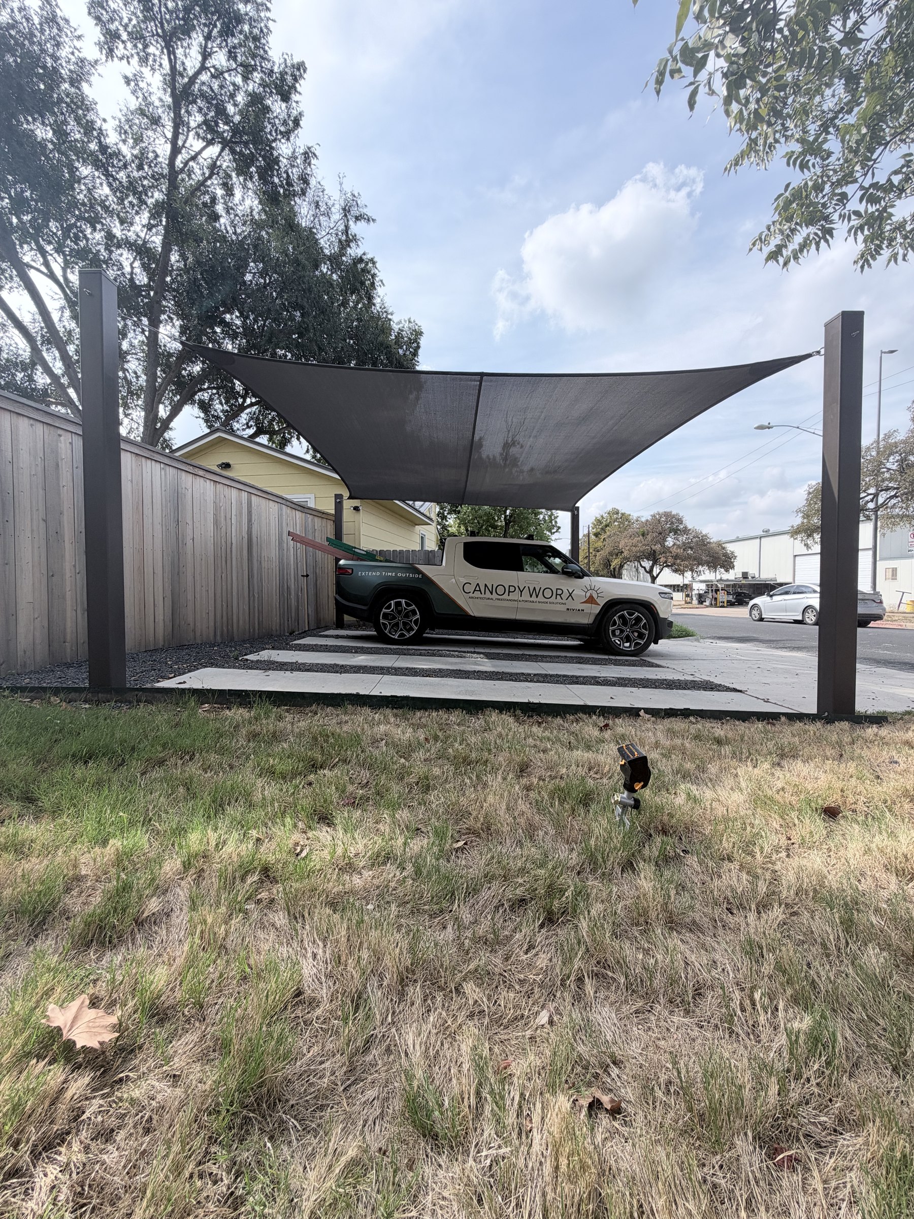 Two-car sail carport framed by four steel posts