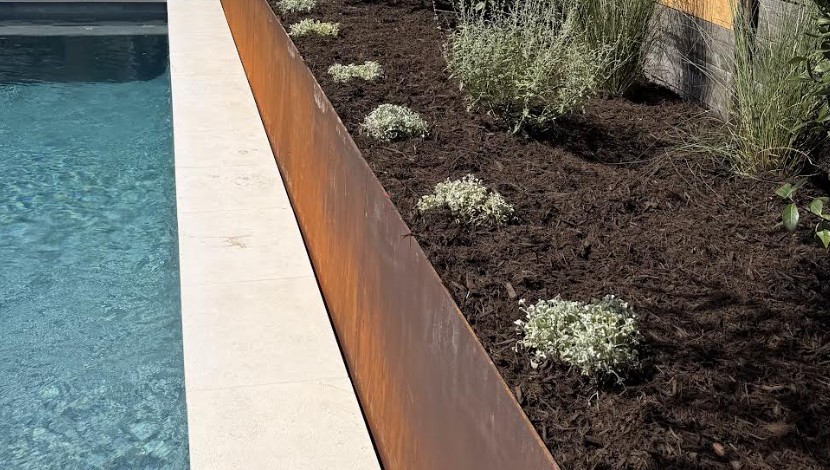 Long weathering steel planter running beside the pool, by Collective Creative Outdoors