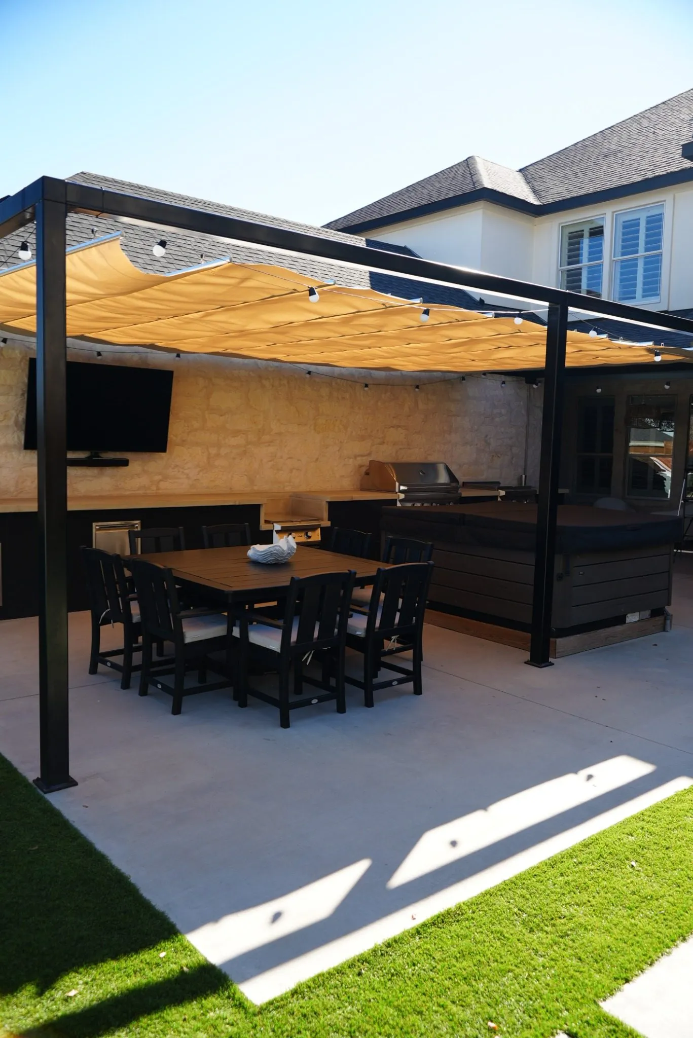 Roman shade over the eight-person dining table, with the grill and hot tub behind