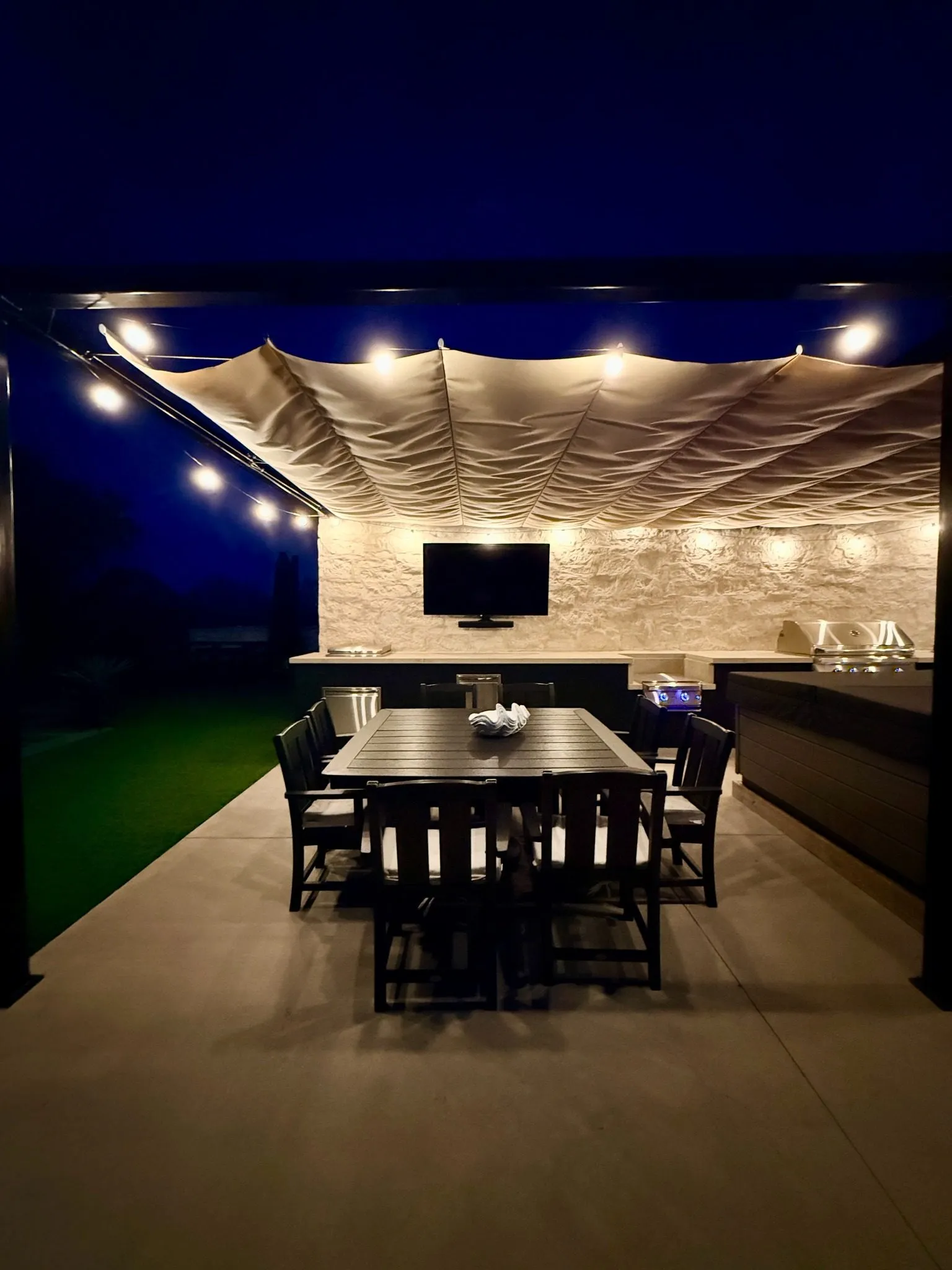 The Lakeway patio at night, with string lights along the Roman shade