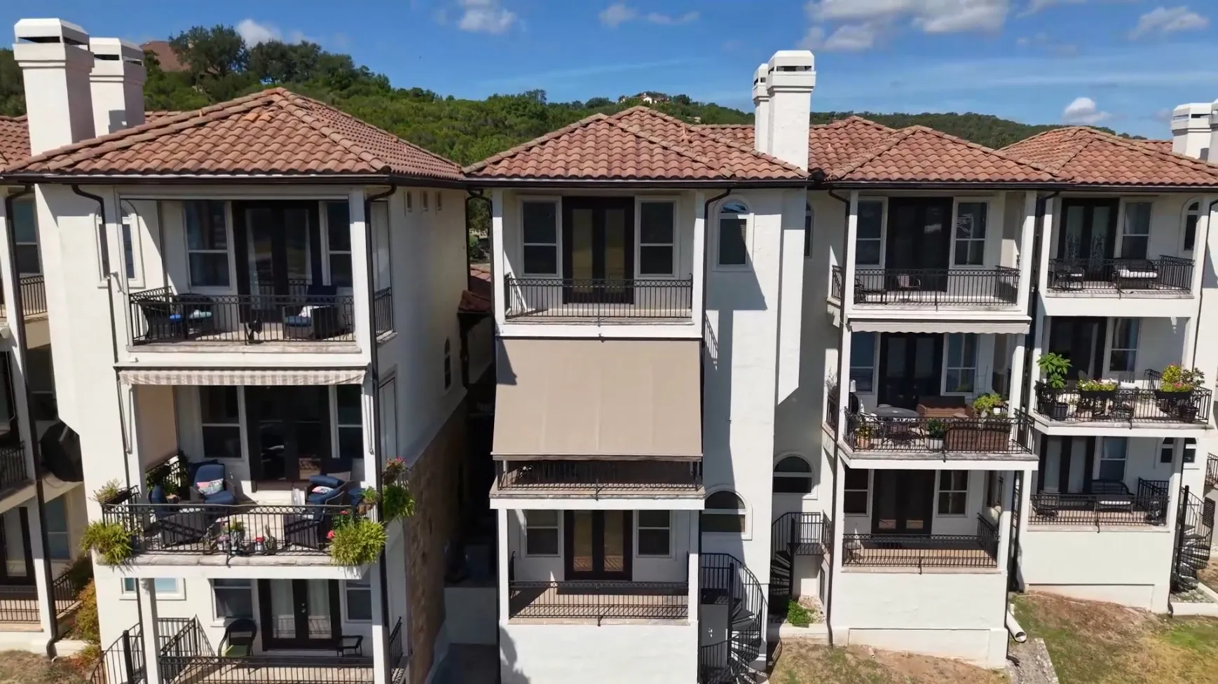 Drone view of the Lake Travis condos, with the motorized awning on the center unit's balcony