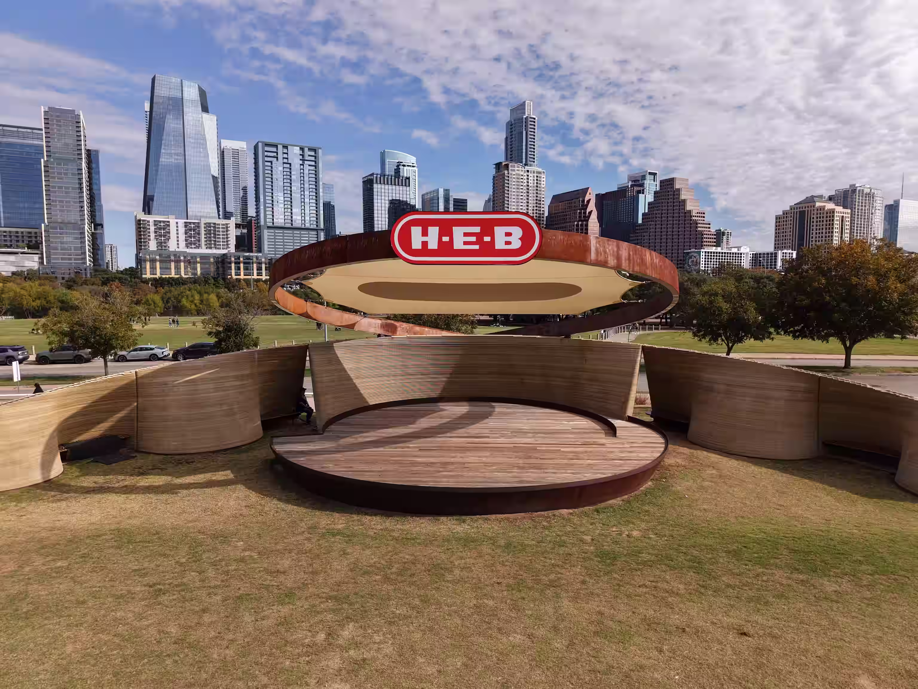 The Long Center amphitheater canopy and H-E-B logo in front of the downtown Austin skyline