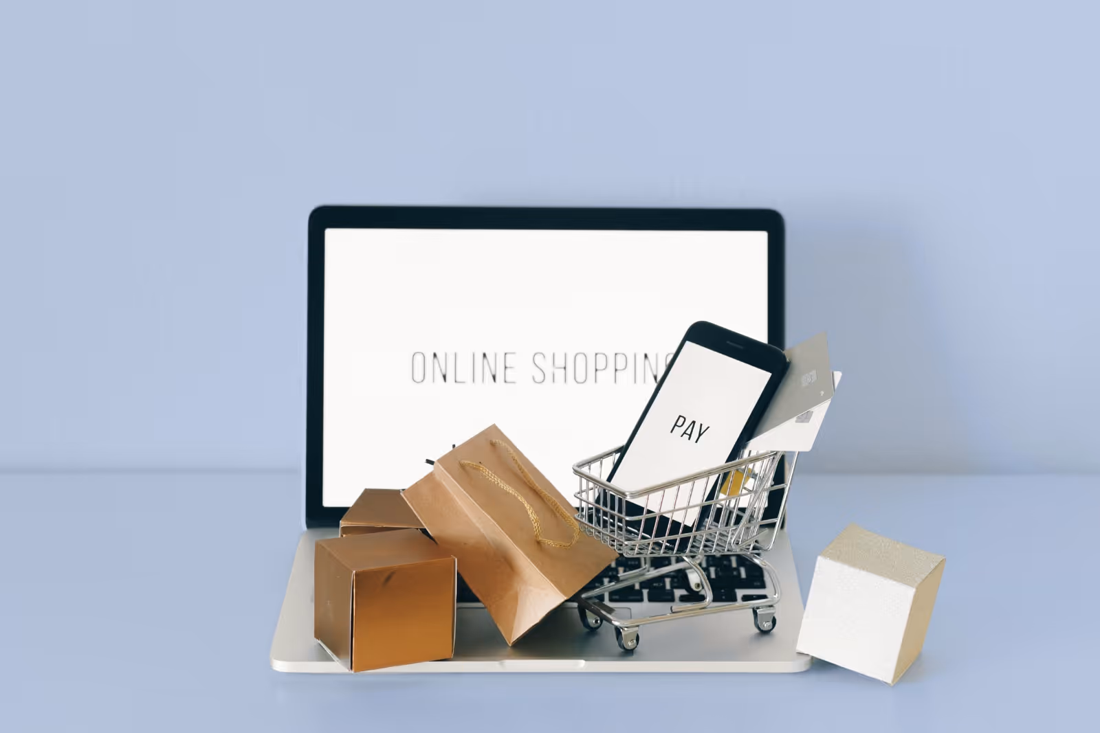 Notebook s textem online nakupování, nákupní vozík s telefonem a kreditní kartou, balíčky.
