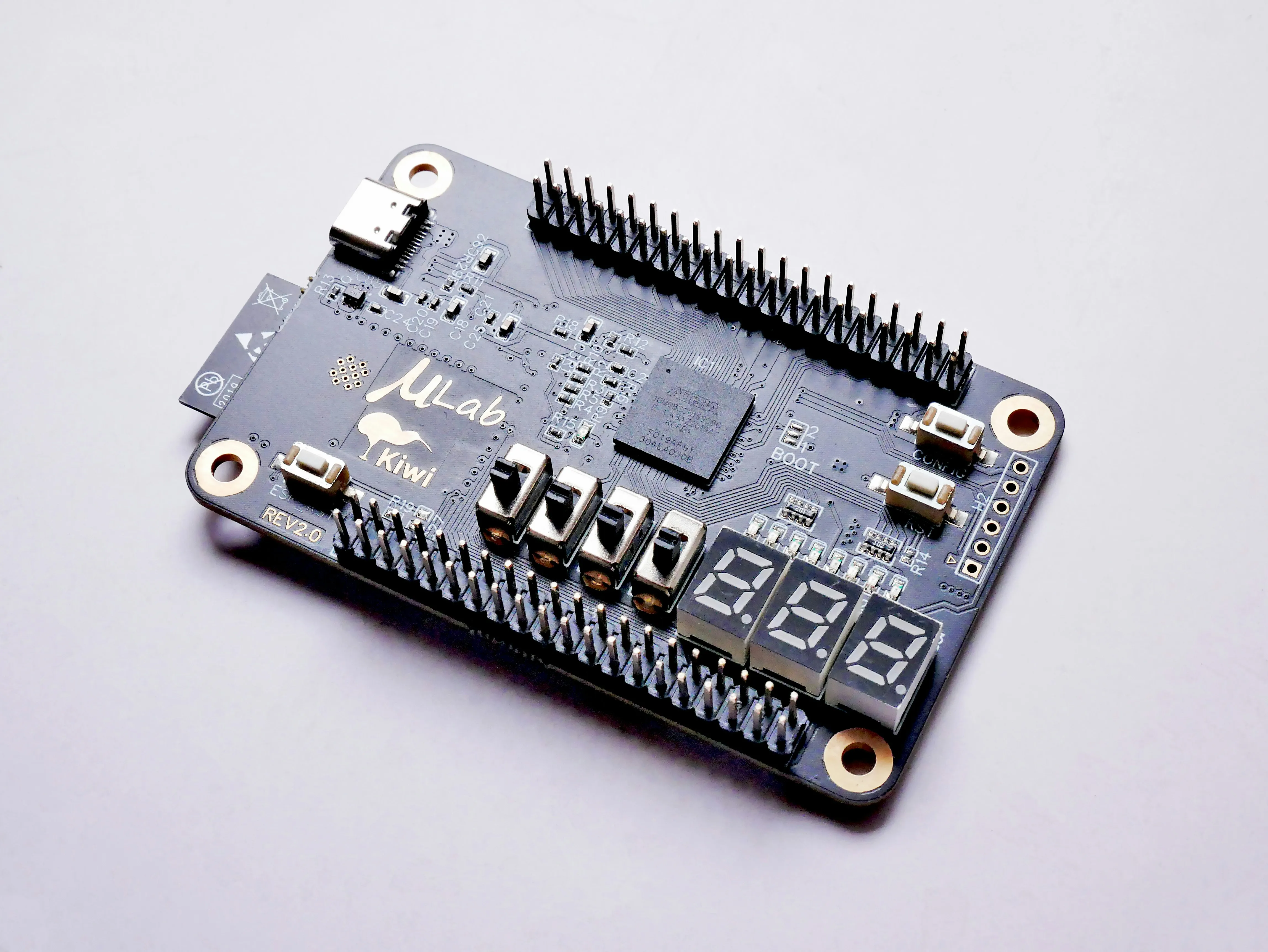 MuLab Kiwi circuit board with pins, switches, USB-C port, and a three-digit segment display.