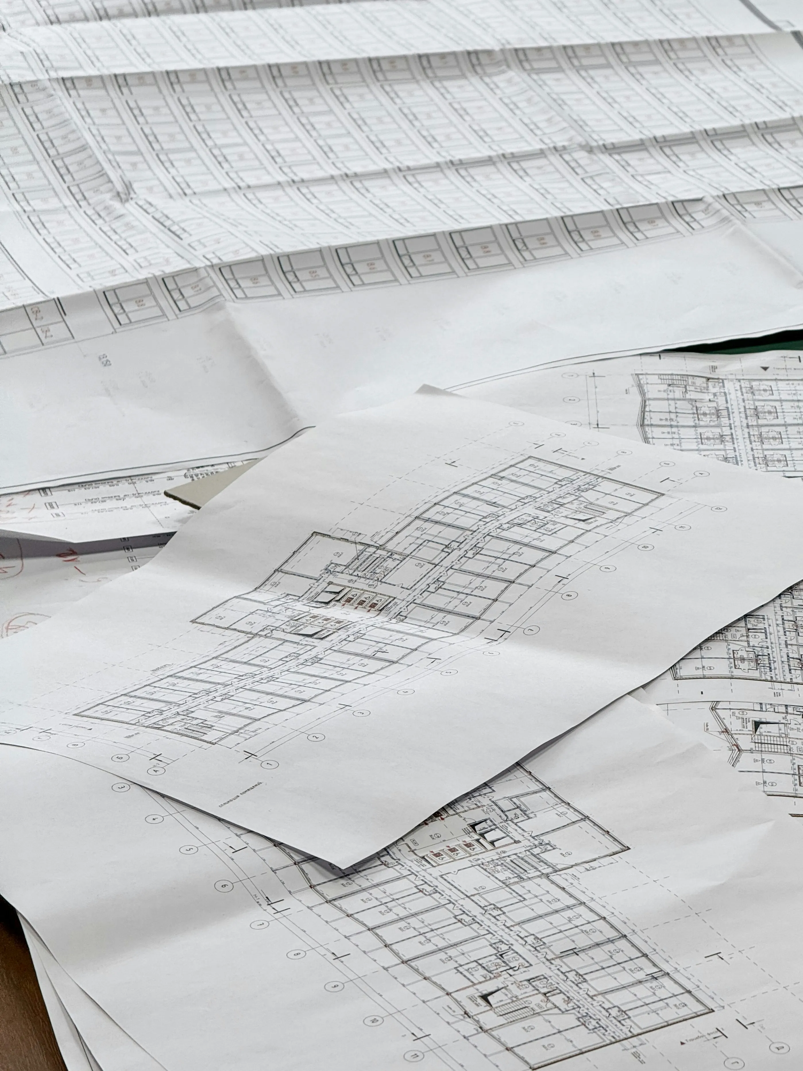 Architectural blueprints and floor plans spread out on a table.