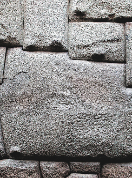 Close-up of large, uneven, ancient stone blocks tightly fitted together in a wall.