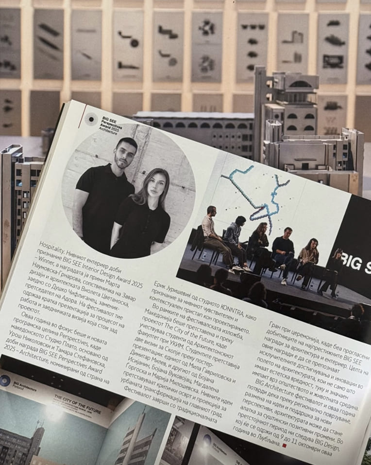 Open magazine page showing photos of two people and a panel discussion with architecture models in background.