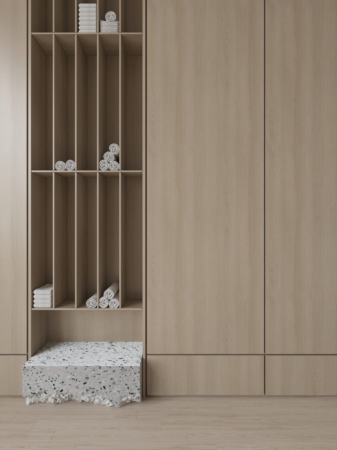 Modern wooden shelving unit with multiple vertical and horizontal compartments holding neatly rolled white towels and stacks of folded towels, next to closed wooden cabinets, and a terrazzo-style stone bench at the bottom.