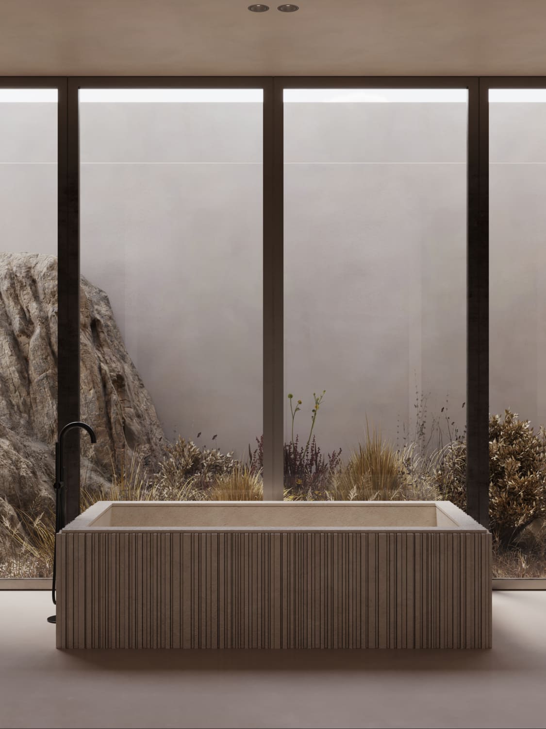 Minimalist indoor bathtub with vertical striped exterior finish positioned in front of large floor-to-ceiling windows showing a rocky landscape with dry grasses and plants outside.