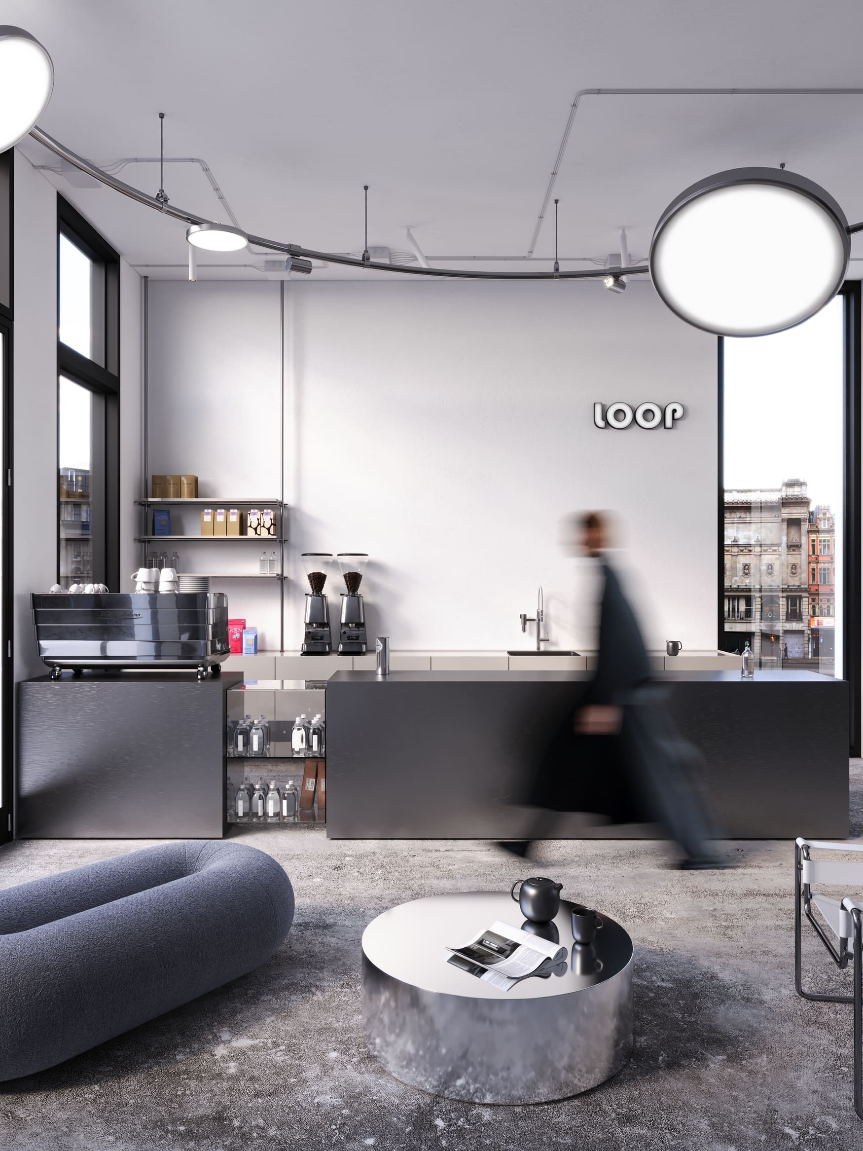Modern coffee shop interior with a sleek black counter, coffee machines, and shelves with coffee supplies; a blurred person walks past. A round metal table holds a teapot, two cups, and an open magazine. A blue cushioned seat and a white chair are nearby, with large windows showing city buildings outside.