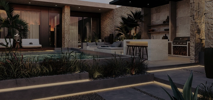 Modern outdoor kitchen area with stone walls, built-in grill, sink, countertop, and potted plants.