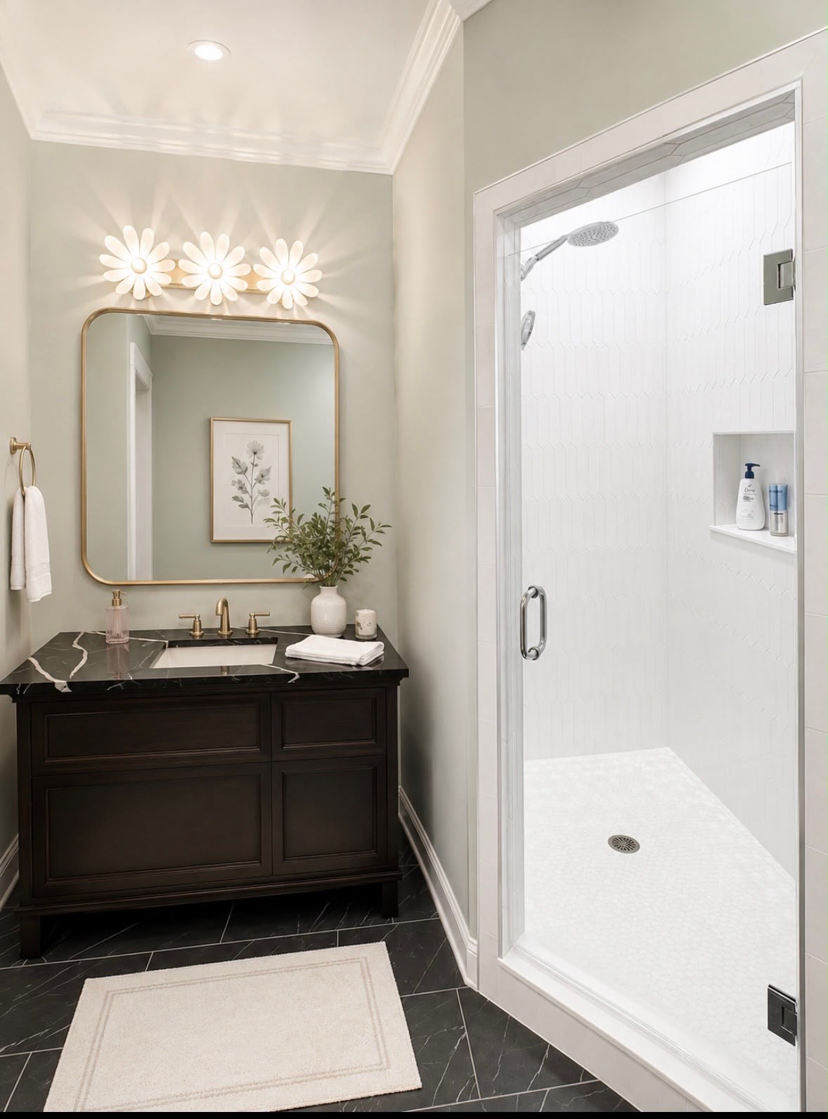 Bathroom with dark wood vanity, floral lights, mirror, towel, and glass shower with white tiles.