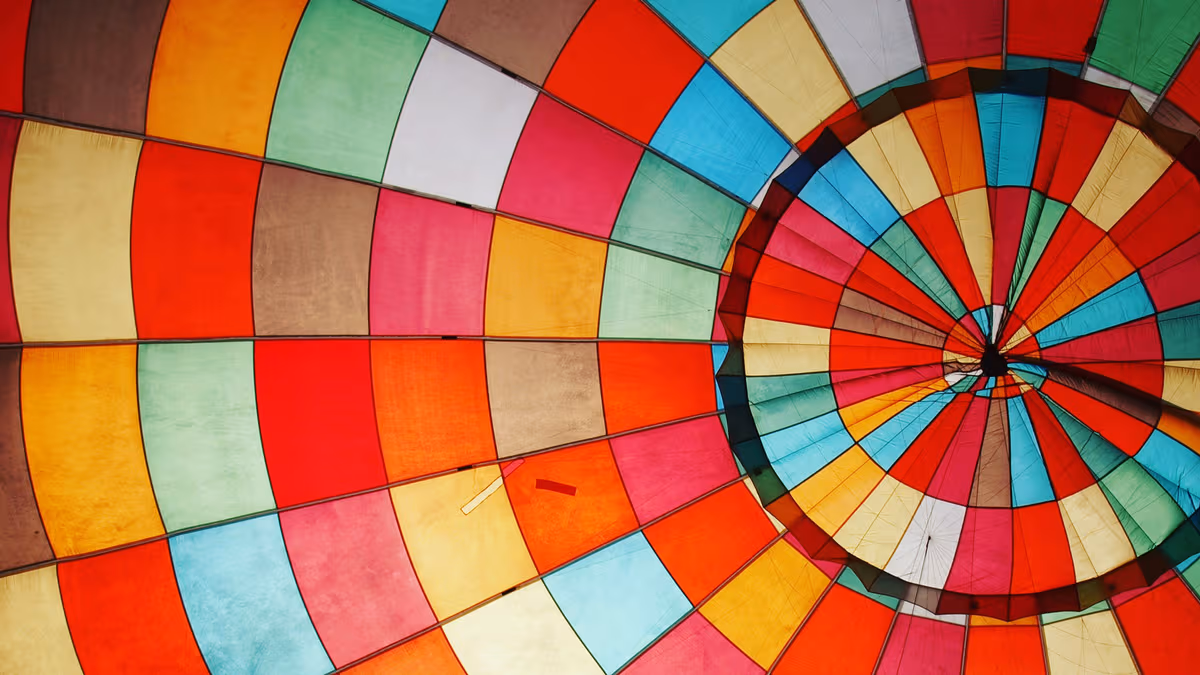 Inside view of a colorful hot air balloon canopy with red, orange, blue, green, and yellow panels.