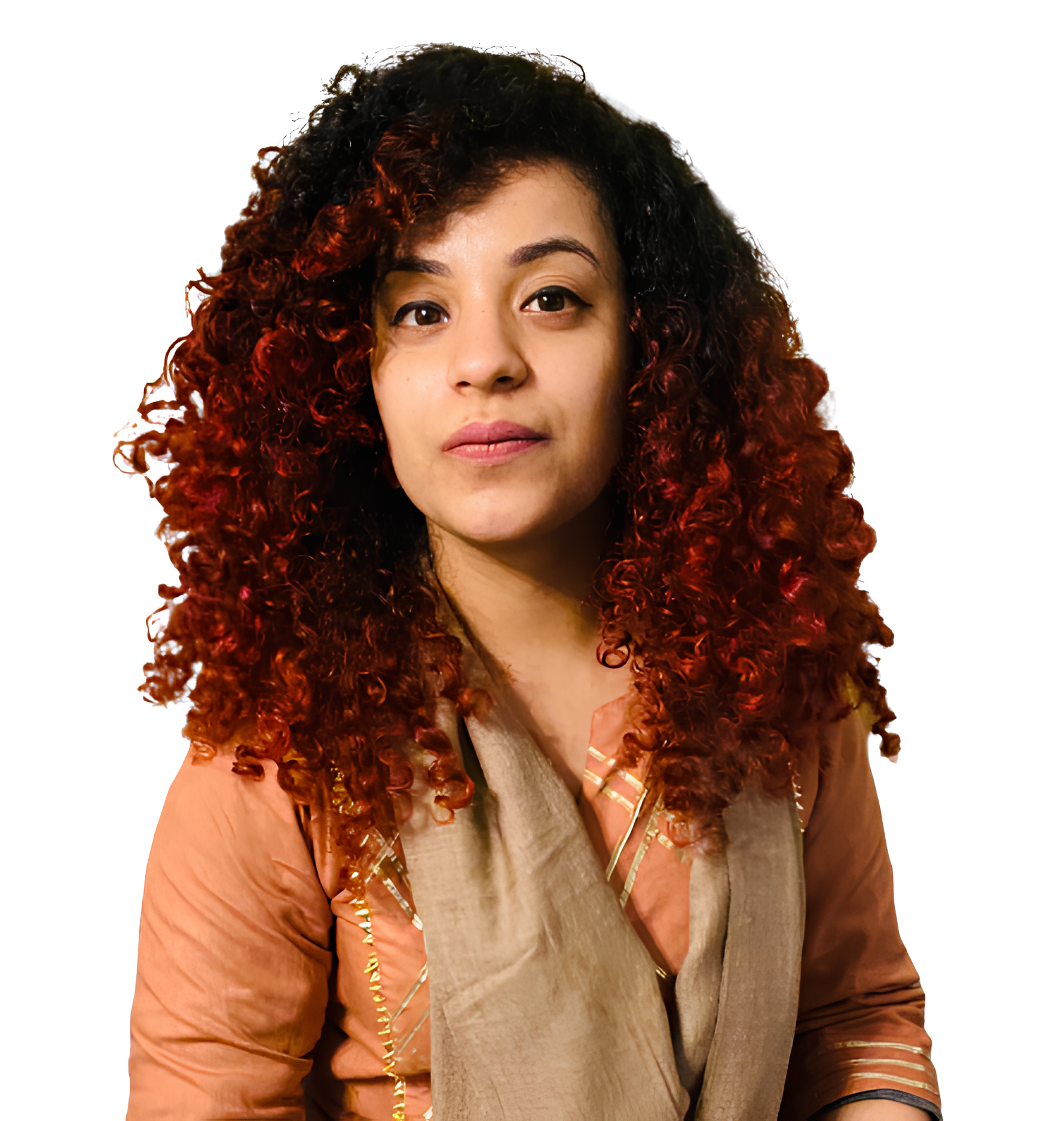 Woman with curly reddish hair wearing a beige scarf and an orange shirt with golden details.