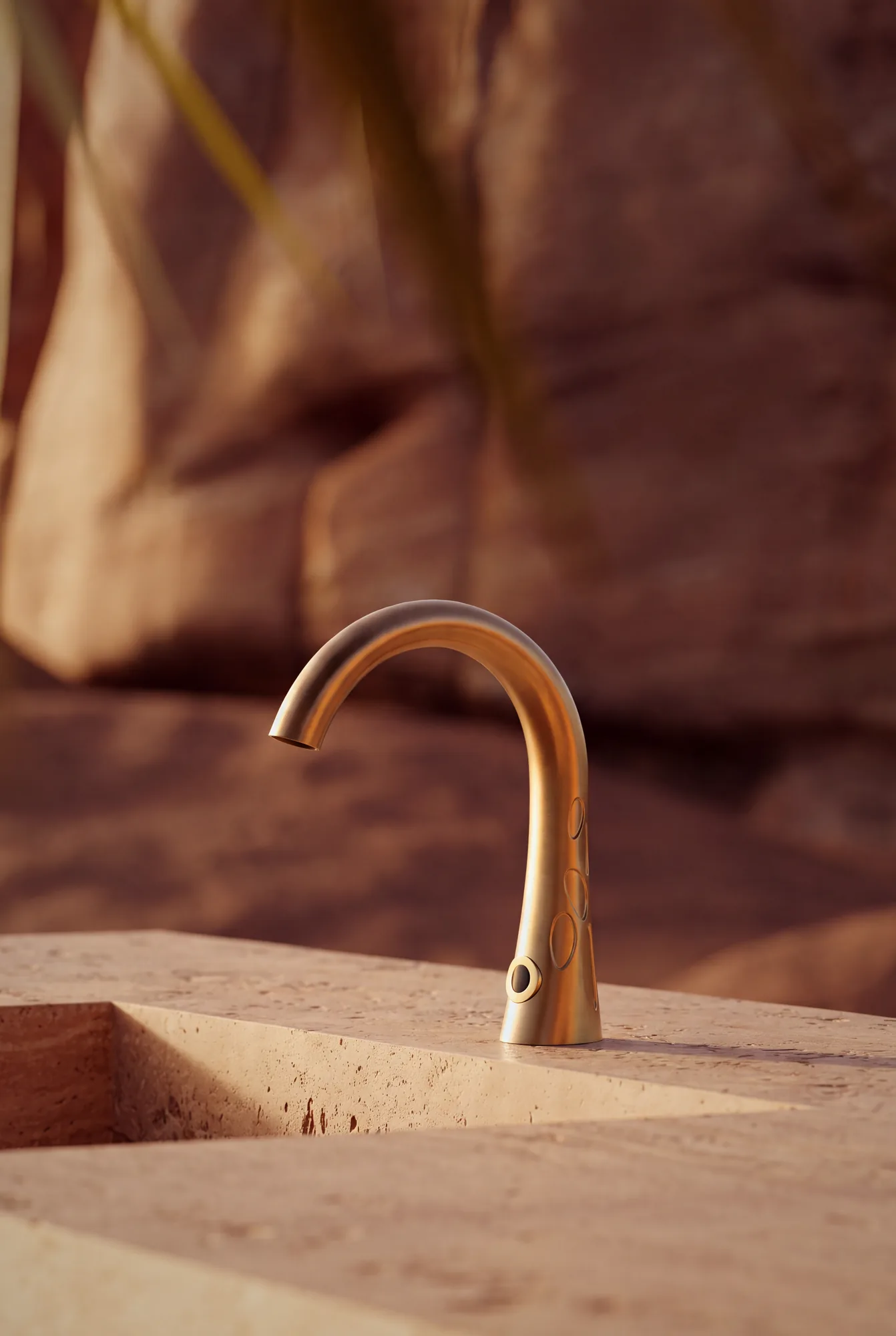 Mirari sensor tap on a travertine basin in a desert setting